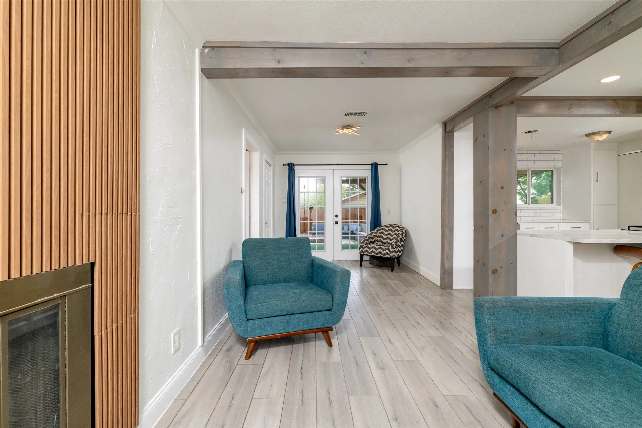 Wood-finish flooring throughout, featuring a fireplace with a wood slat surround