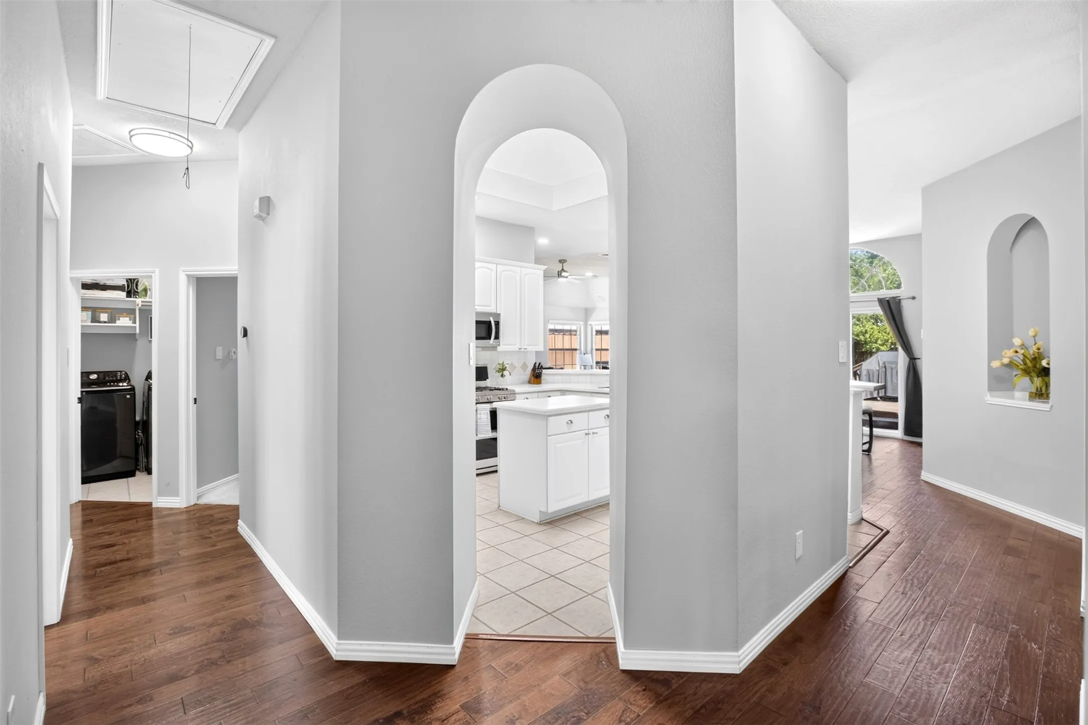 Arched doorways, wood-finish flooring, and a built-in wall niche