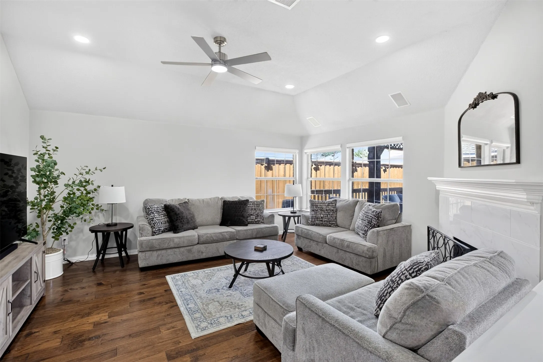 Vaulted ceiling with recessed lighting and a ceiling fan