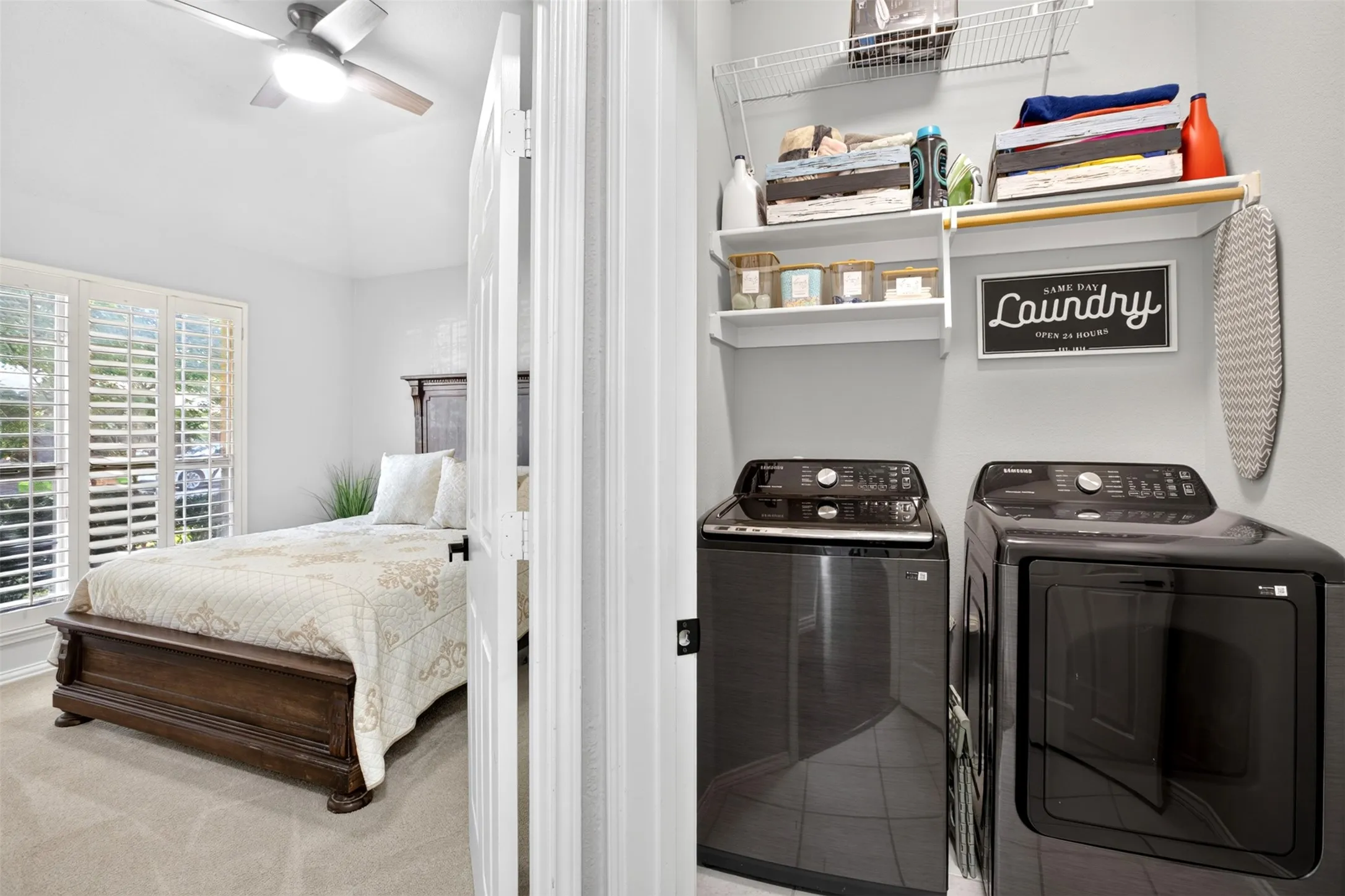 Compact laundry area featuring built-in shelving, a clothes hanging rod, and tile flooring