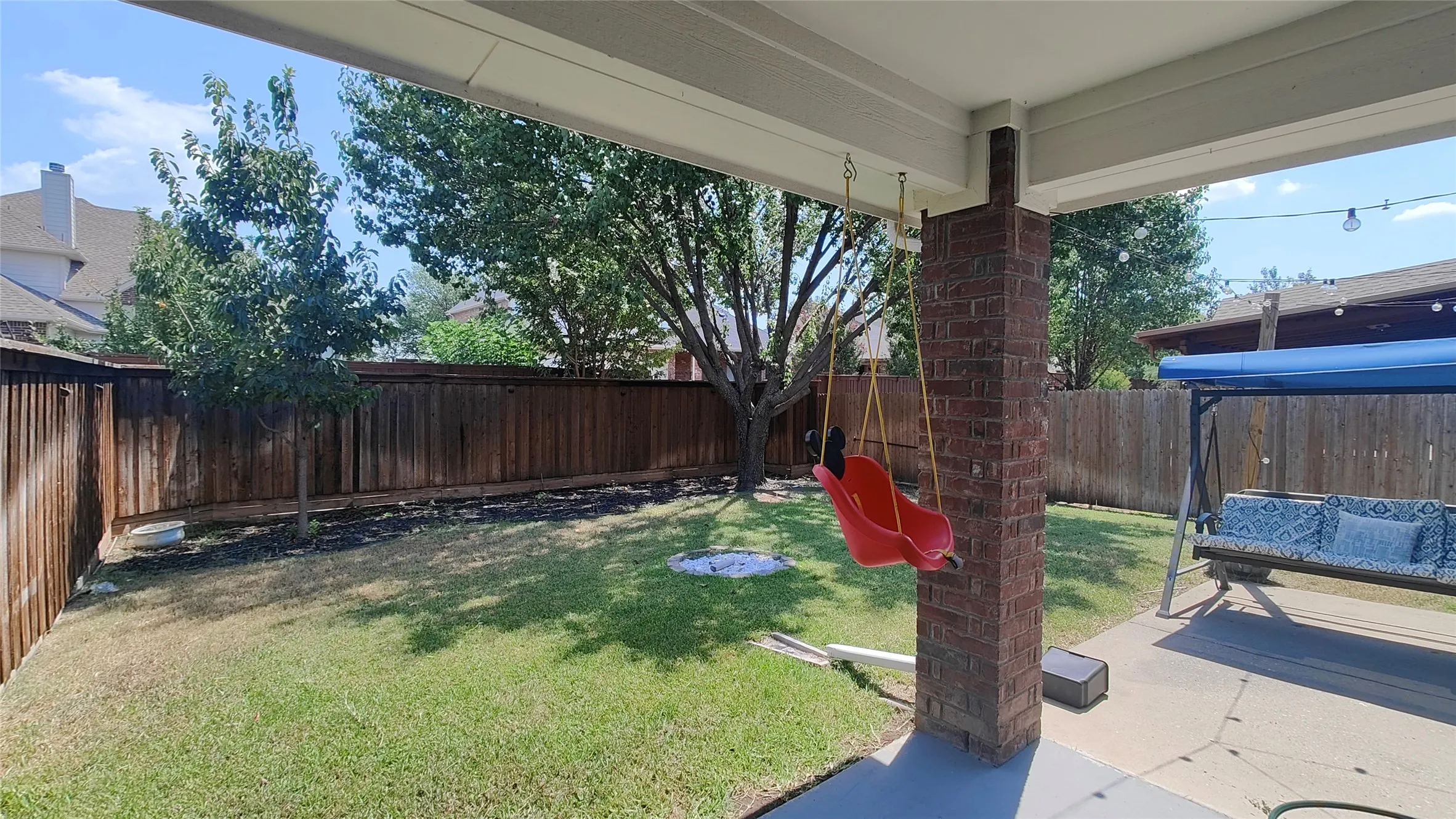 Covered patio featuring a brick column and concrete flooring