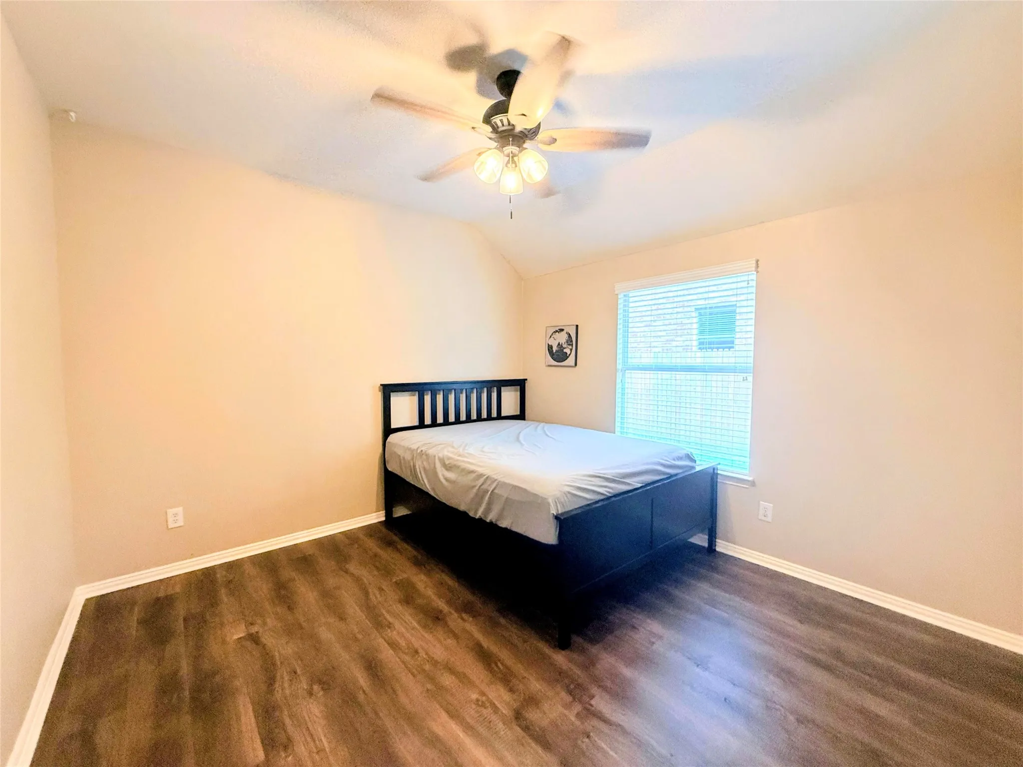 Vaulted ceiling with a ceiling fan, wood-finish flooring, and a window with horizontal blinds