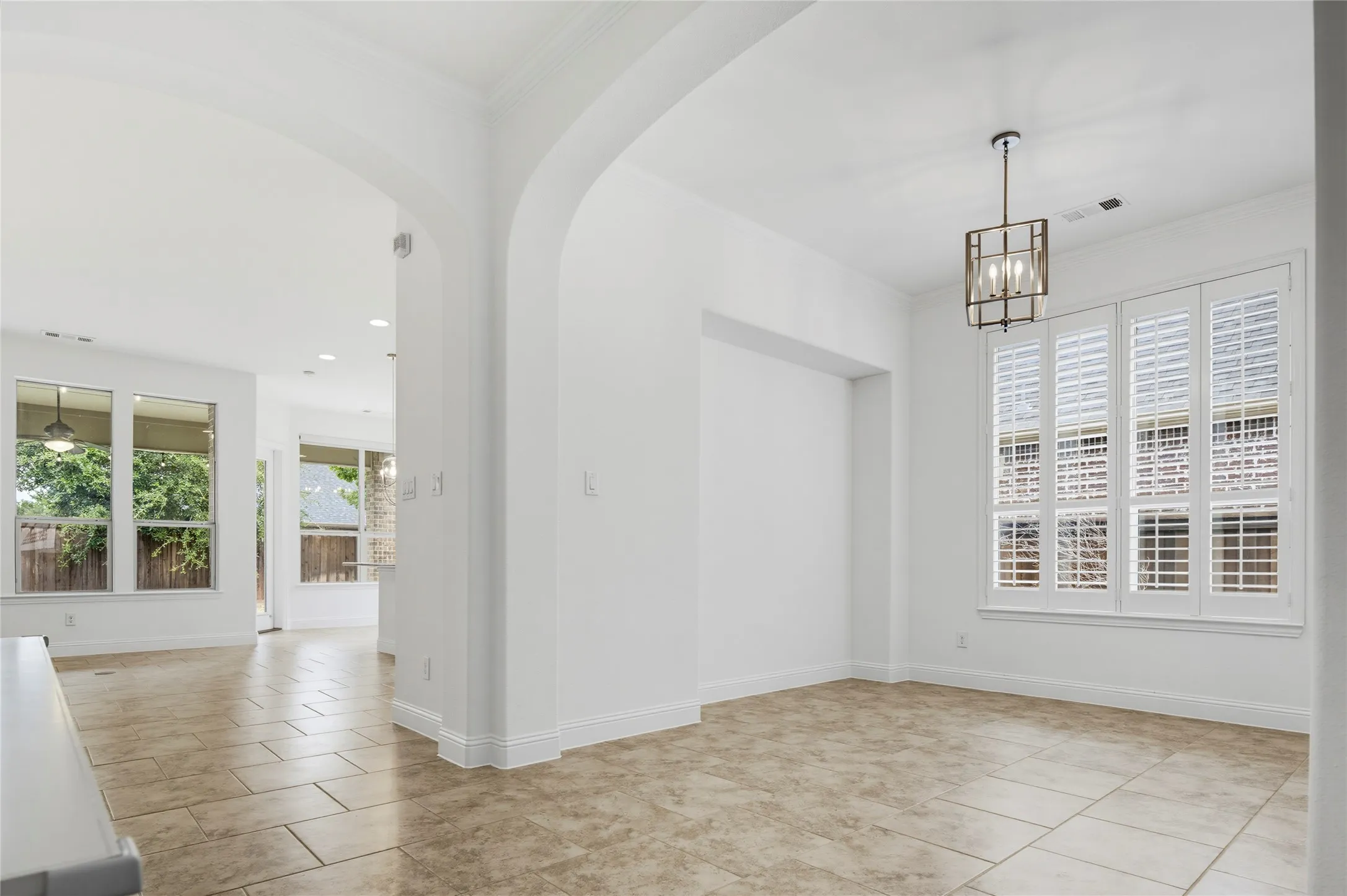 Archways define the entry to an open-concept space featuring tile flooring