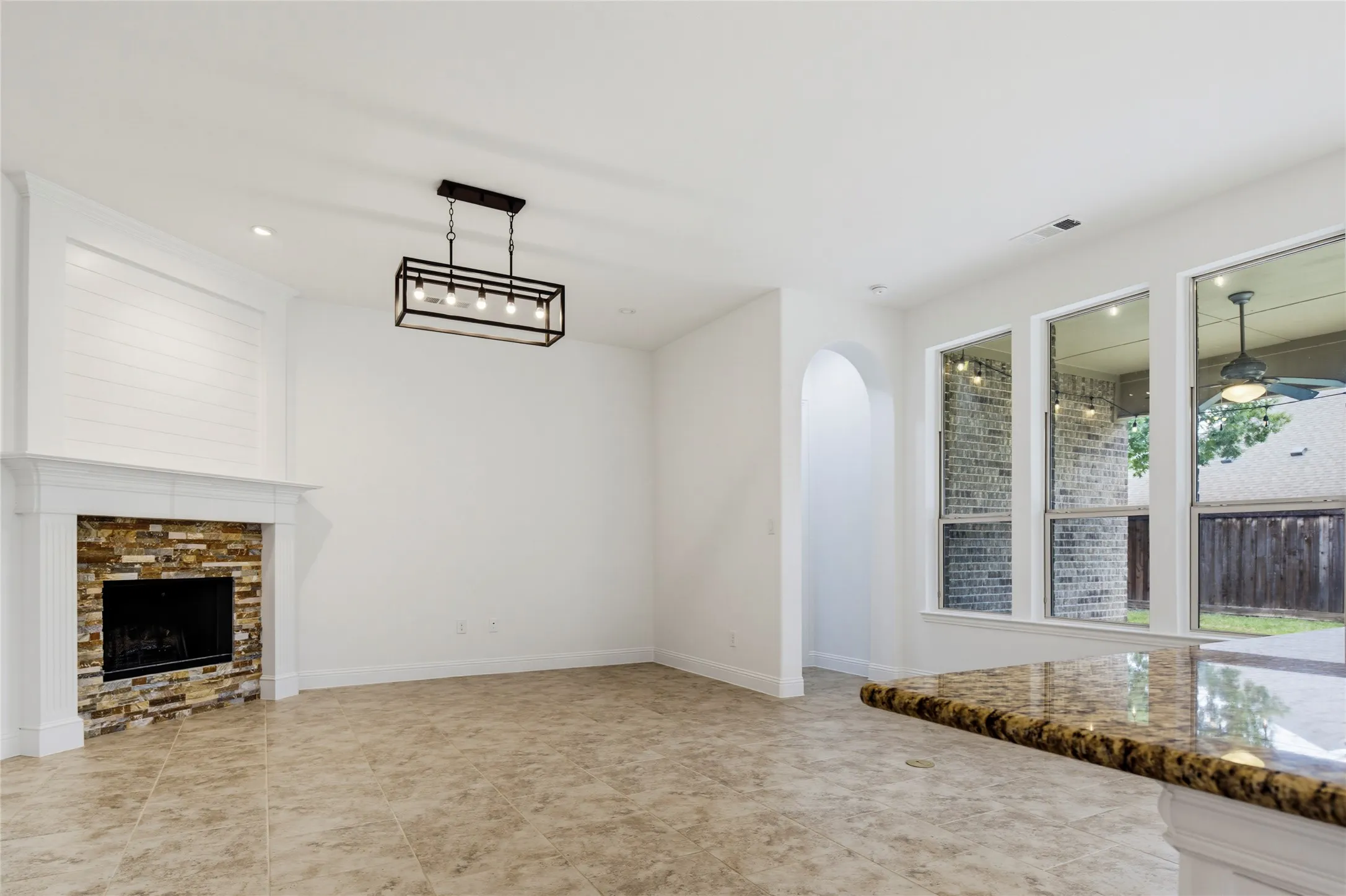 Built-in fireplace with a stone-tile surround, white mantel, and shiplap detailing