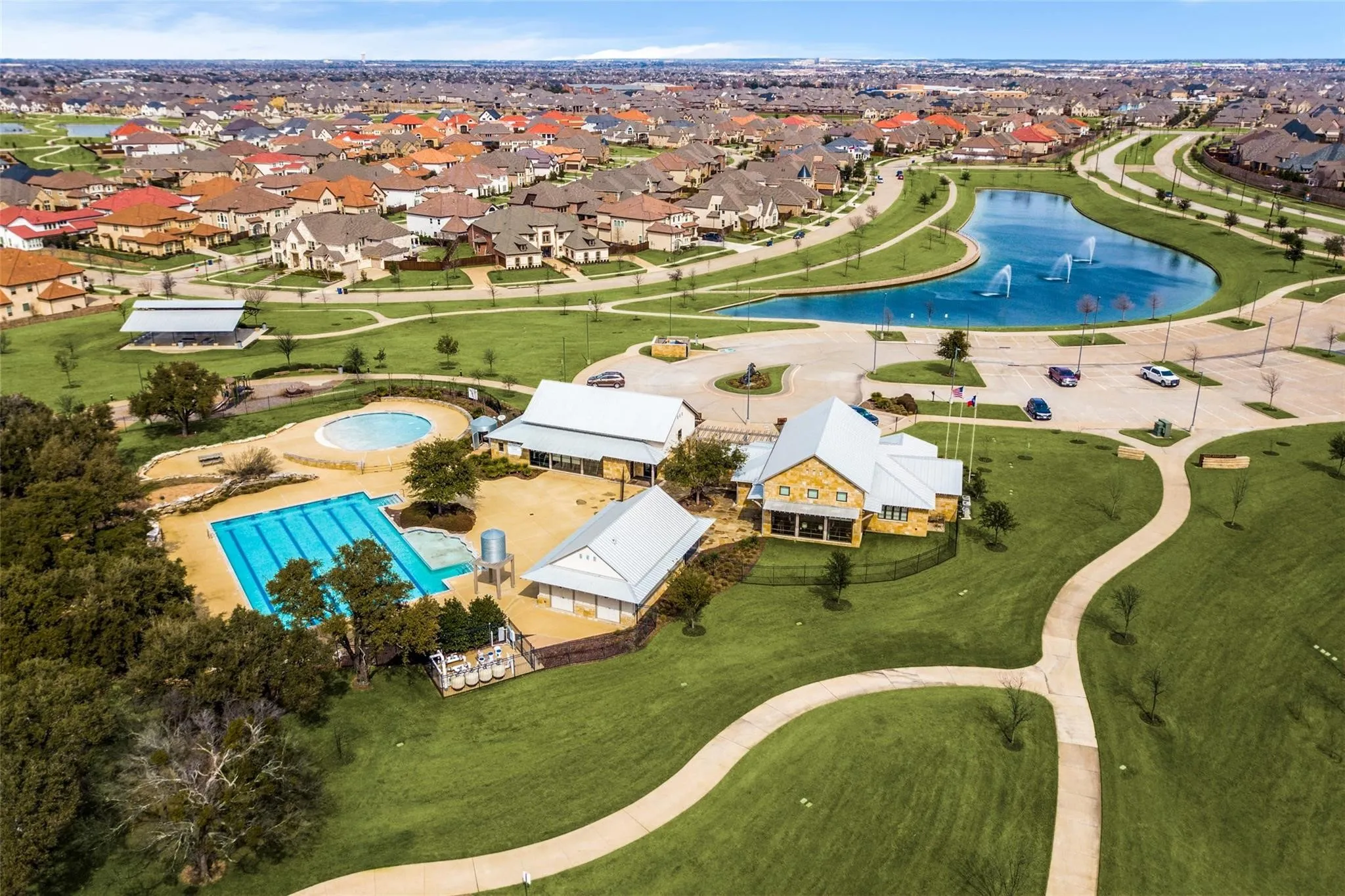 Community amenities featuring multiple swimming pools, a central pond with water features, extensive green spaces, and paved walking paths