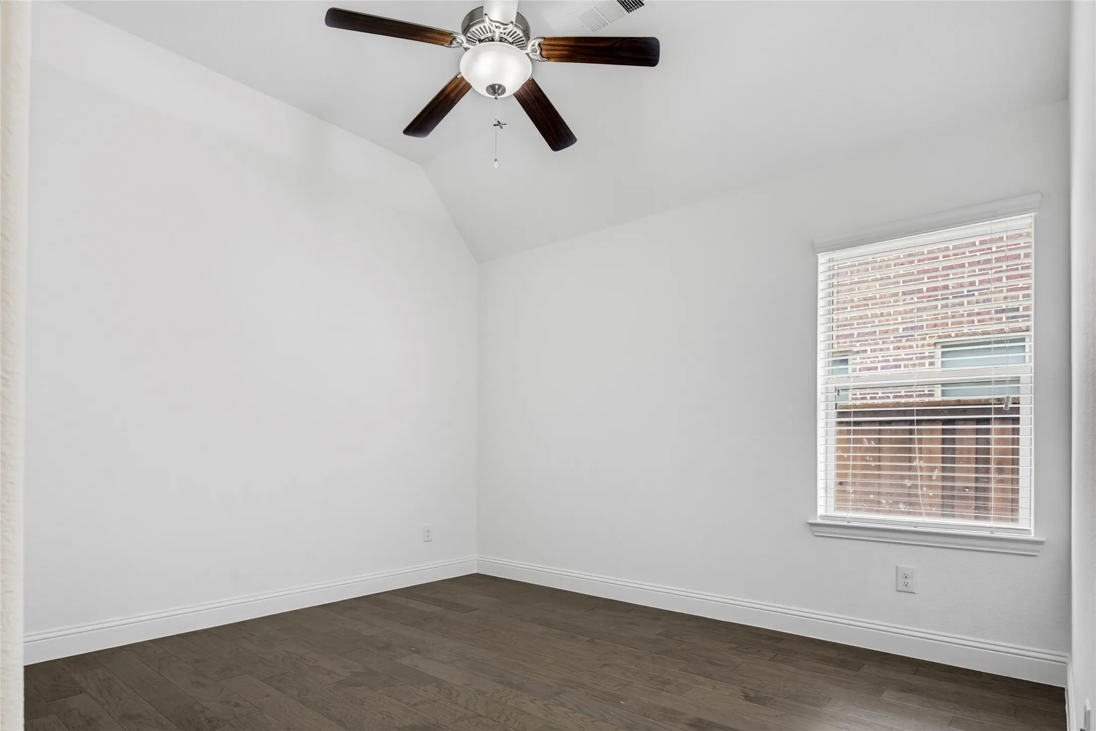 Room with vaulted ceiling, wood-finish flooring, a window with blinds, and a ceiling fan