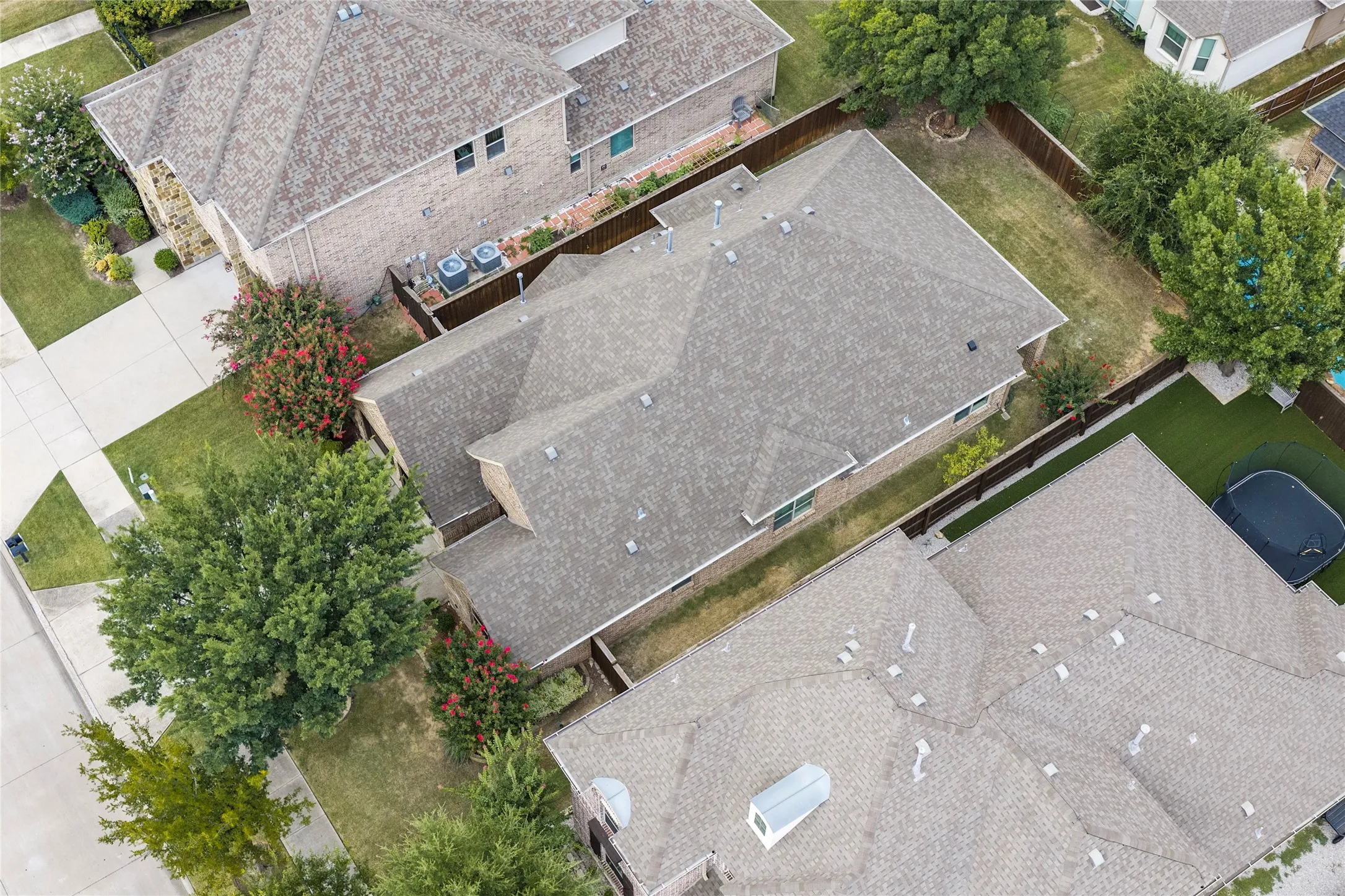 Asphalt shingle roof, brick exterior, fenced yard, mature landscaping, concrete driveway