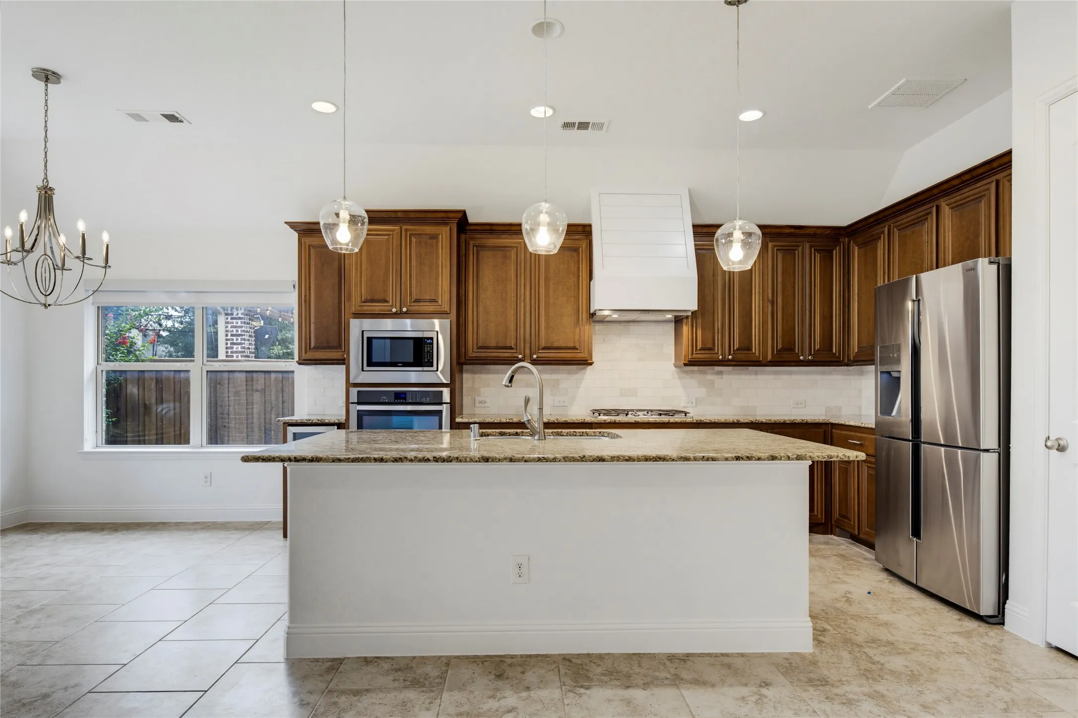 Kitchen featuring a large island, wood cabinetry, stainless steel appliances, and recessed lighting