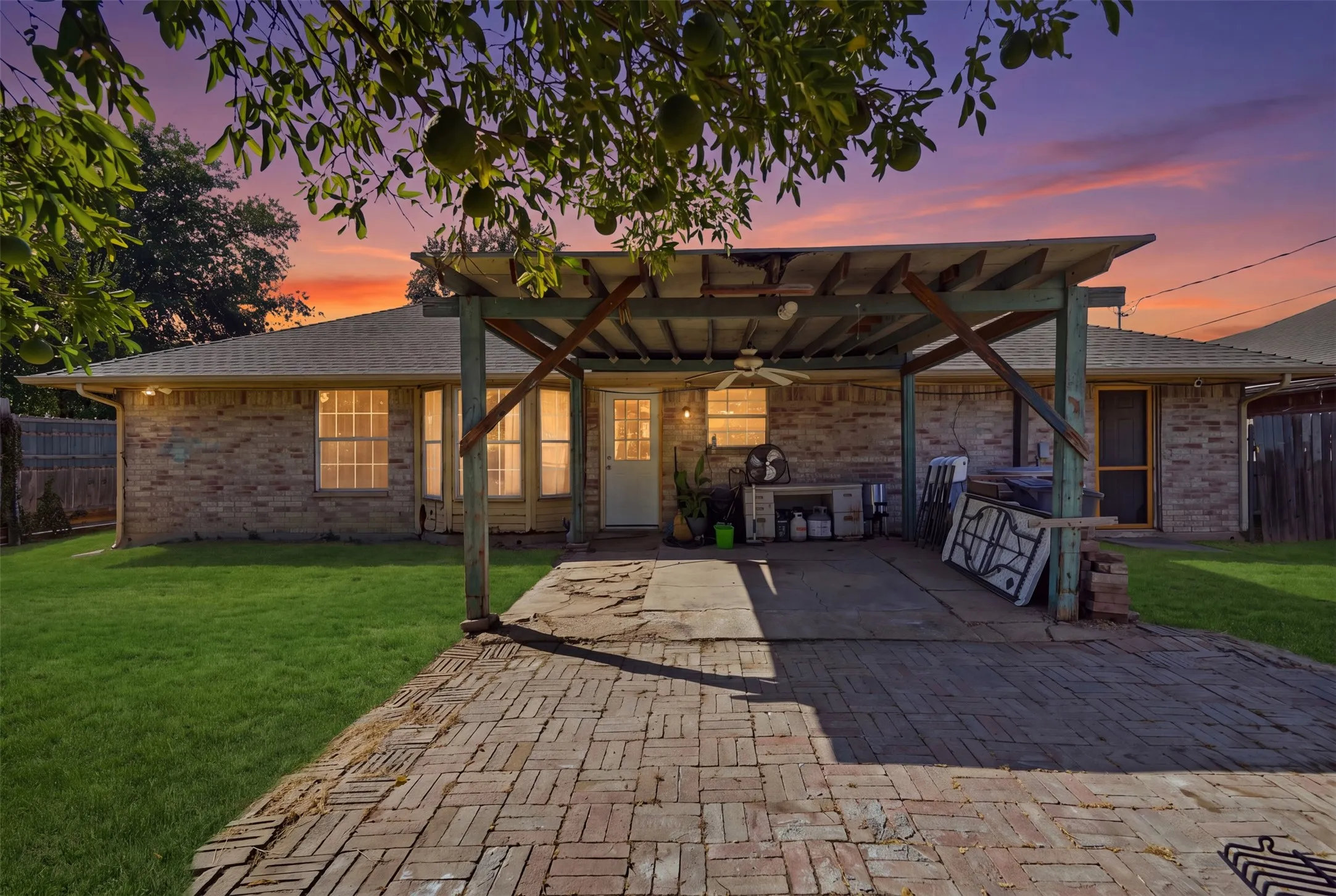 Brick exterior with a covered patio, a ceiling fan, and a paver patio surface