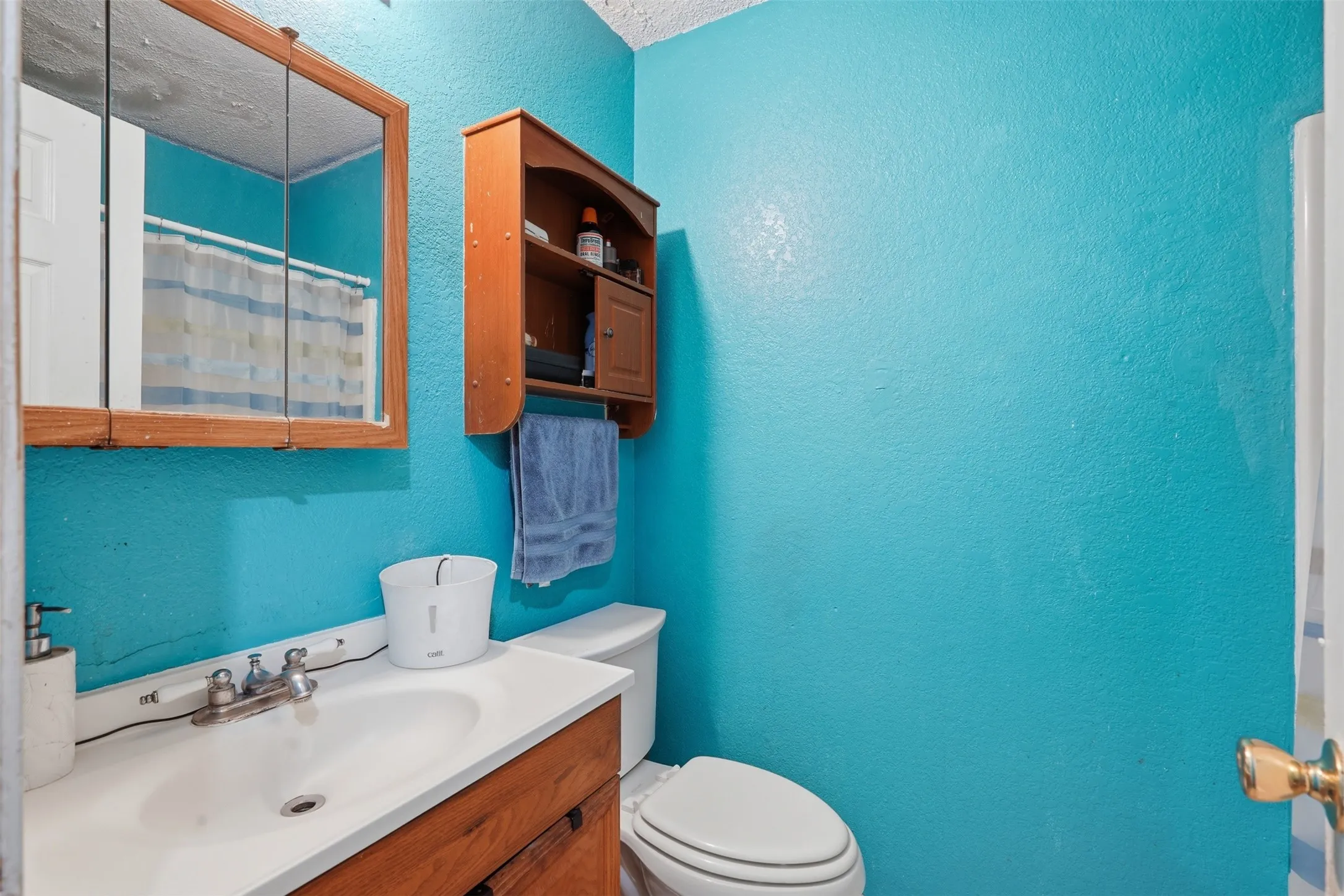 Built-in wood-finish medicine cabinet, wood-finish vanity with an integrated sink, and wall-mounted wood-finish shelving unit