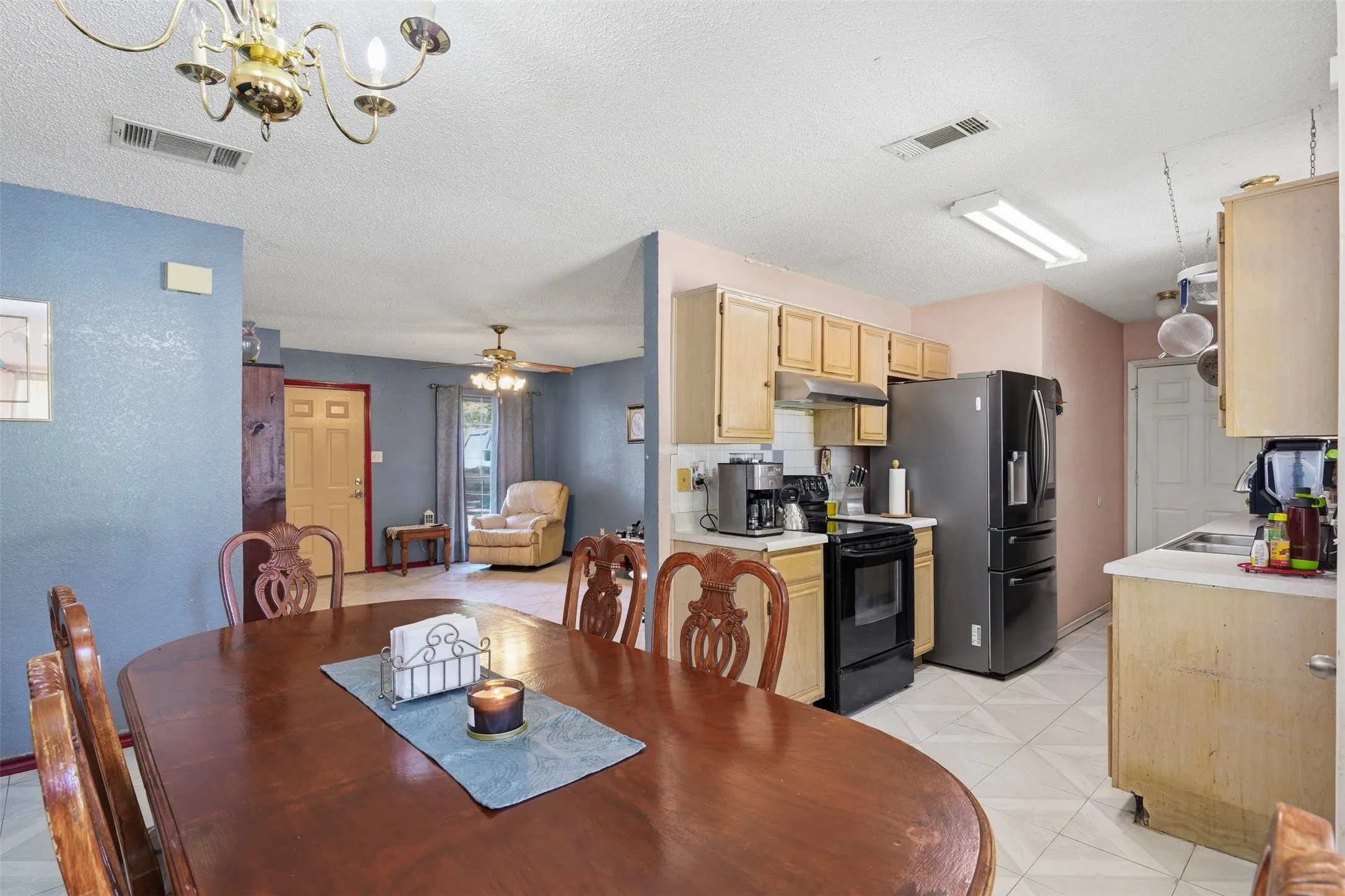 Kitchen with wood-finish cabinetry, white countertops, and black appliances