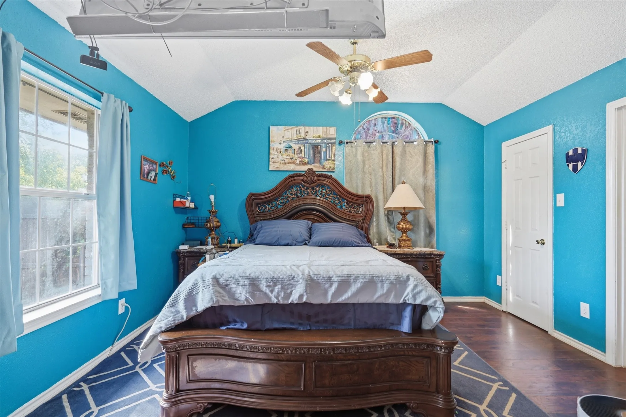 Vaulted ceilings, wood-finish flooring, and a ceiling fan