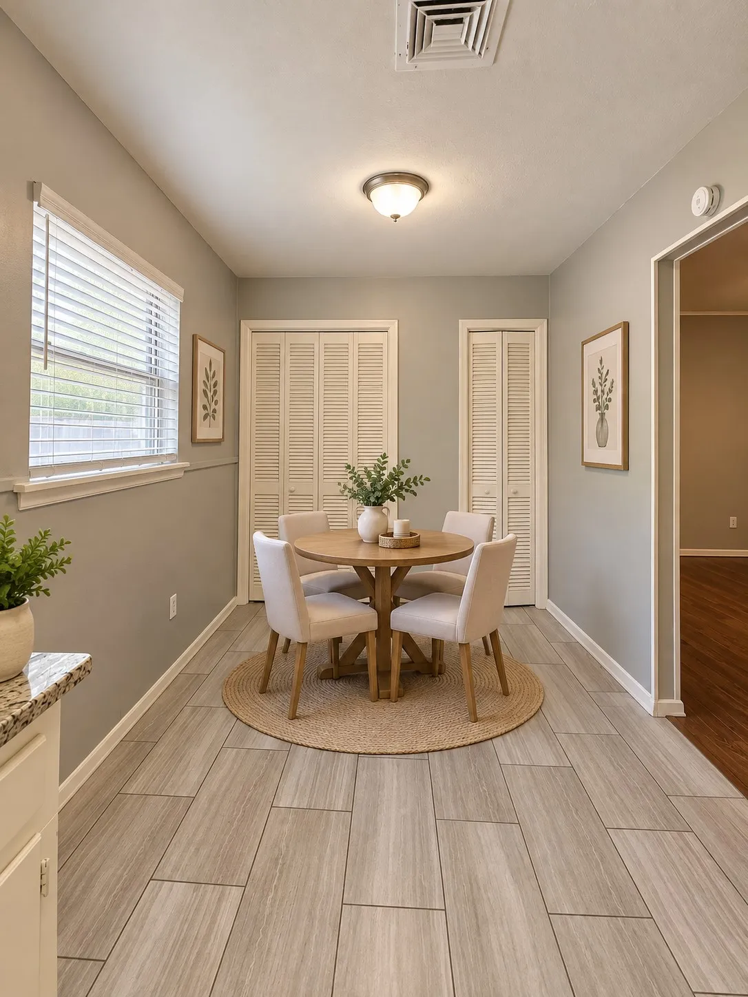 Light-toned wood-look tile flooring, white window blinds, and white louvered bifold doors