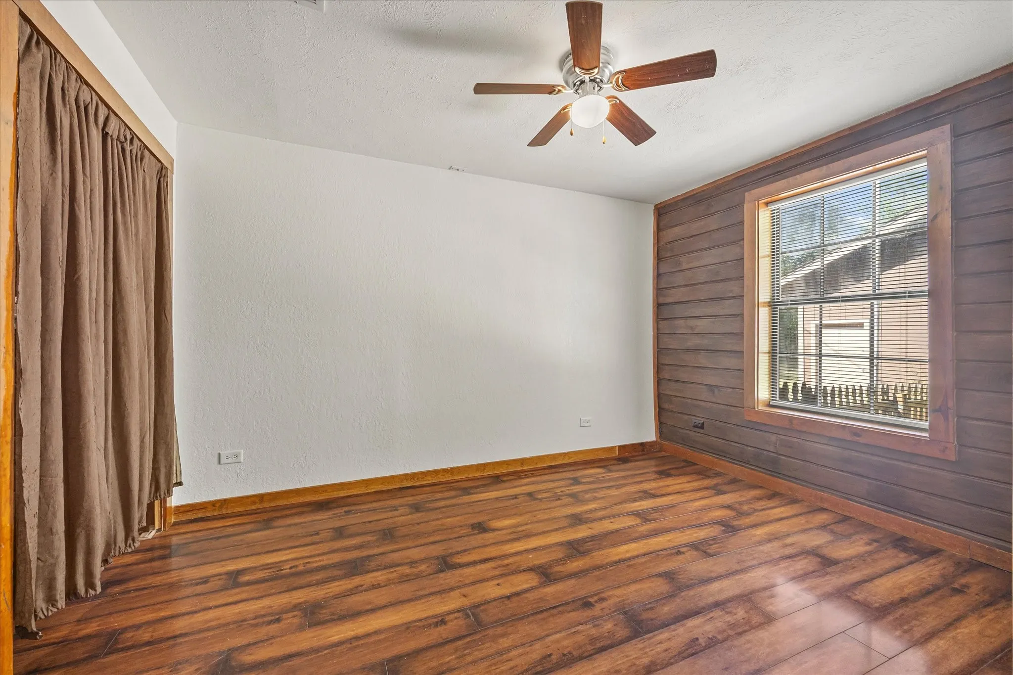 Bedroom 3 with plank floors and ceiling fan.