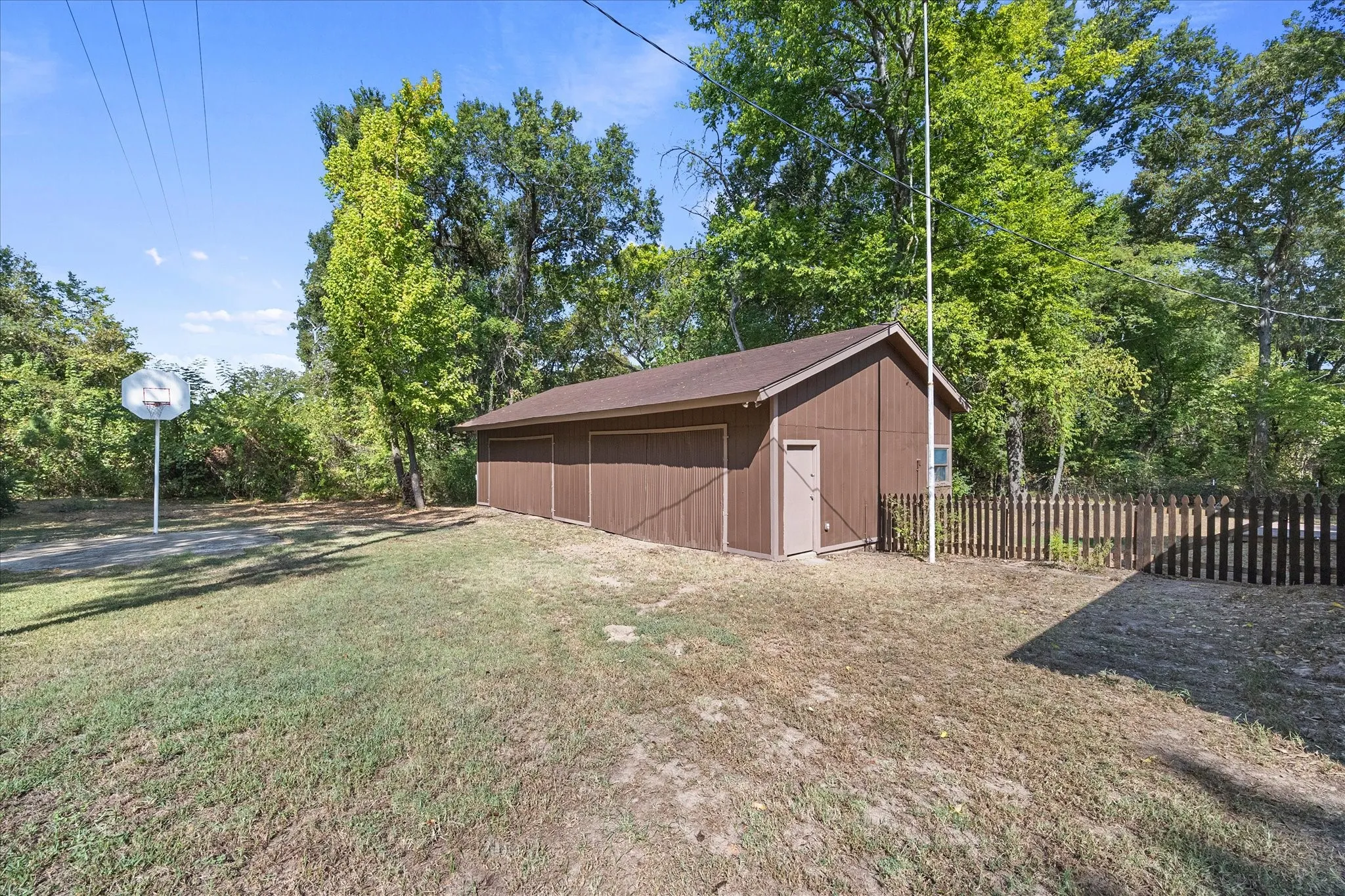 Four car garage and workshop with loft storage for all your toys and projects. Relax with a game of basketball on the concrete pad in front.