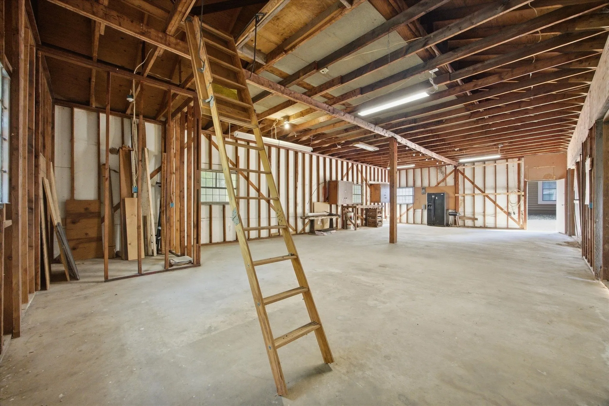 Interior view of 1145 SF four-car garage and workshop with attic storage and electric.