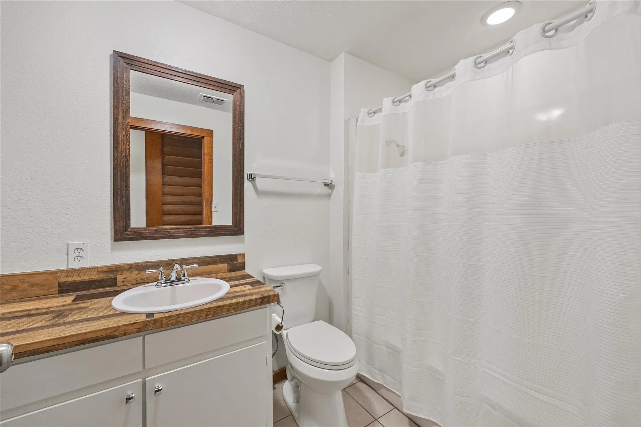 Hall bathroom has tub-shower combo, fresh paint and tile floors.