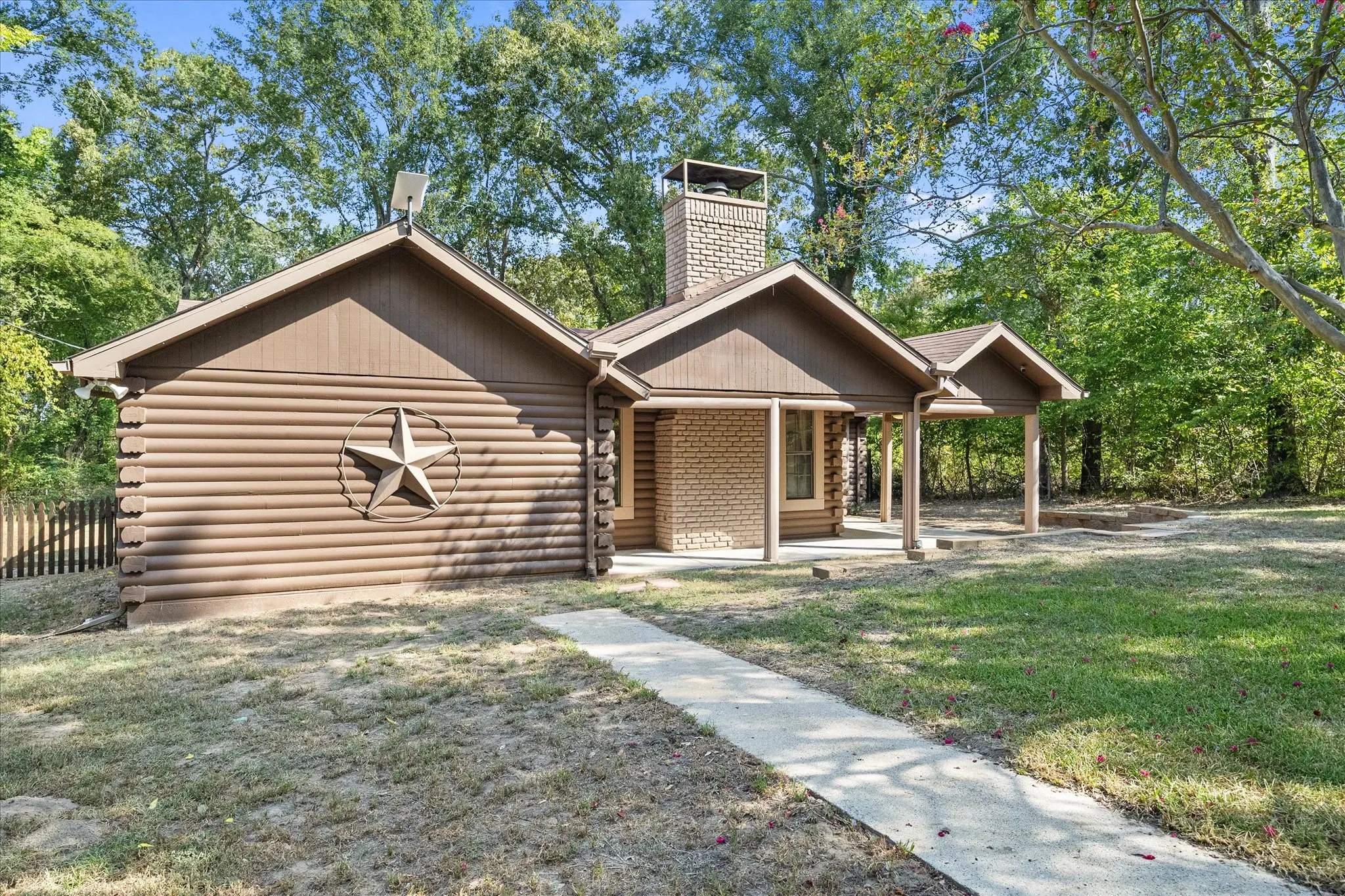 Another view of front of this beautiful 3/3 log home with stone fireplace.