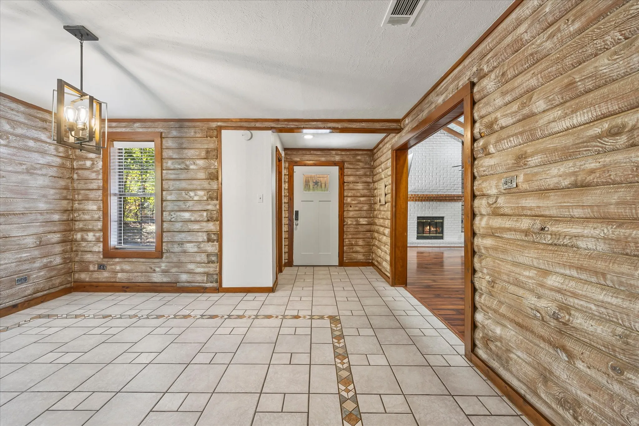 Entryway opens to the main living and dining areas. The home was freshly painted and freshened in September 2026. Note the detail in the logs and woodworS