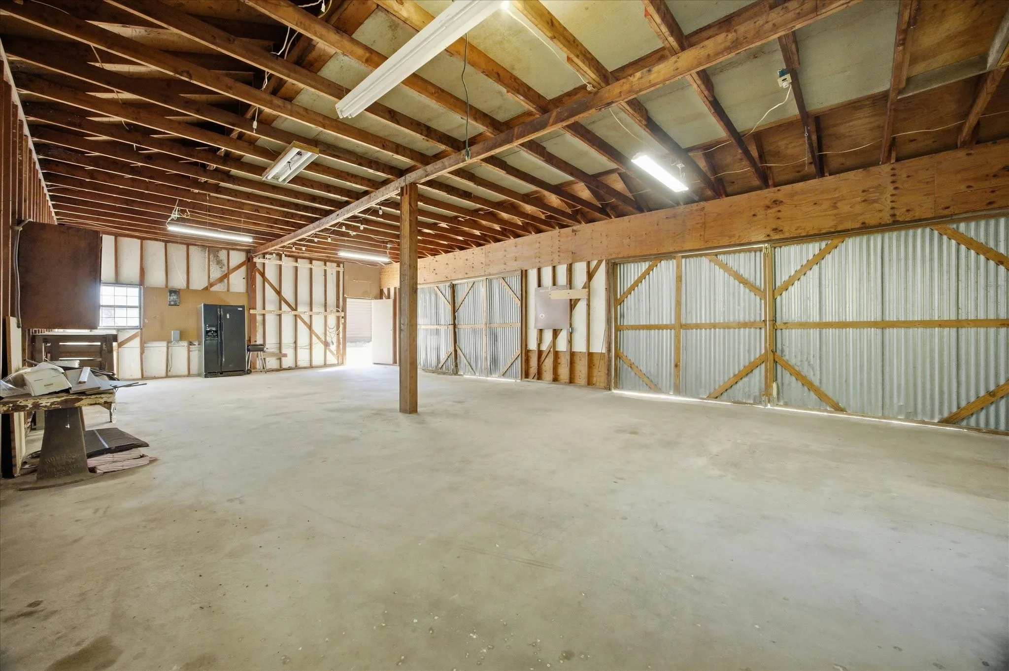 Four car garage and workshop with electric. Two sets of double doors for vehicle access. Attic storage above.