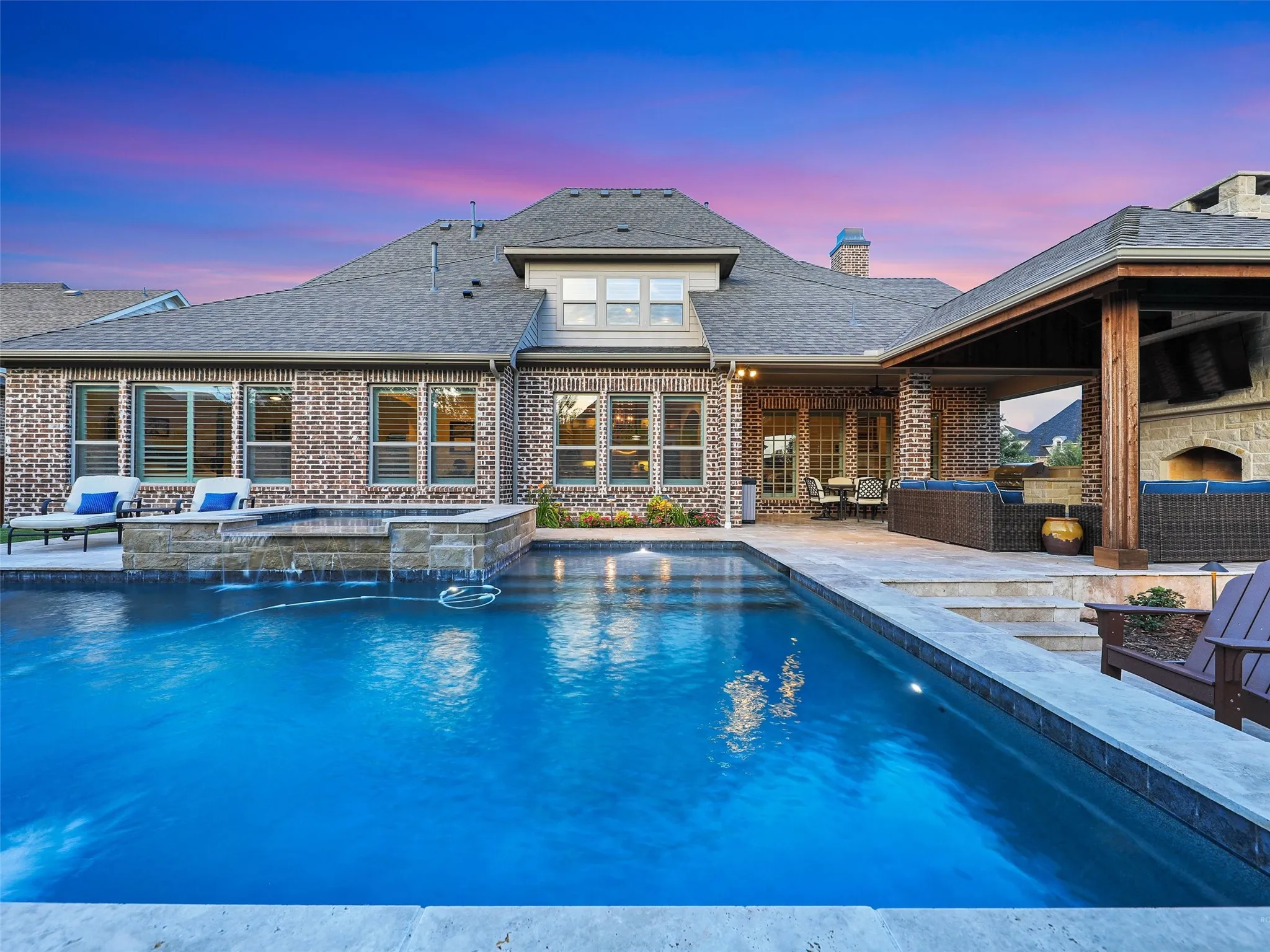 Outside, the property transforms into a private resort designed for year-round enjoyment. The Foley Pools swimming pool, completed in 2021, is complemented by an oversized spa with seating for approximately 10. Travertine limestone surrounds the pool and is used throughout the decking and coping, giving the outdoor environment a cohesive, upscale finish. Pentair pool equipment with wireless controls provides convenient operation, while individual pumps for the pool features allow greater flexibility and independent control.