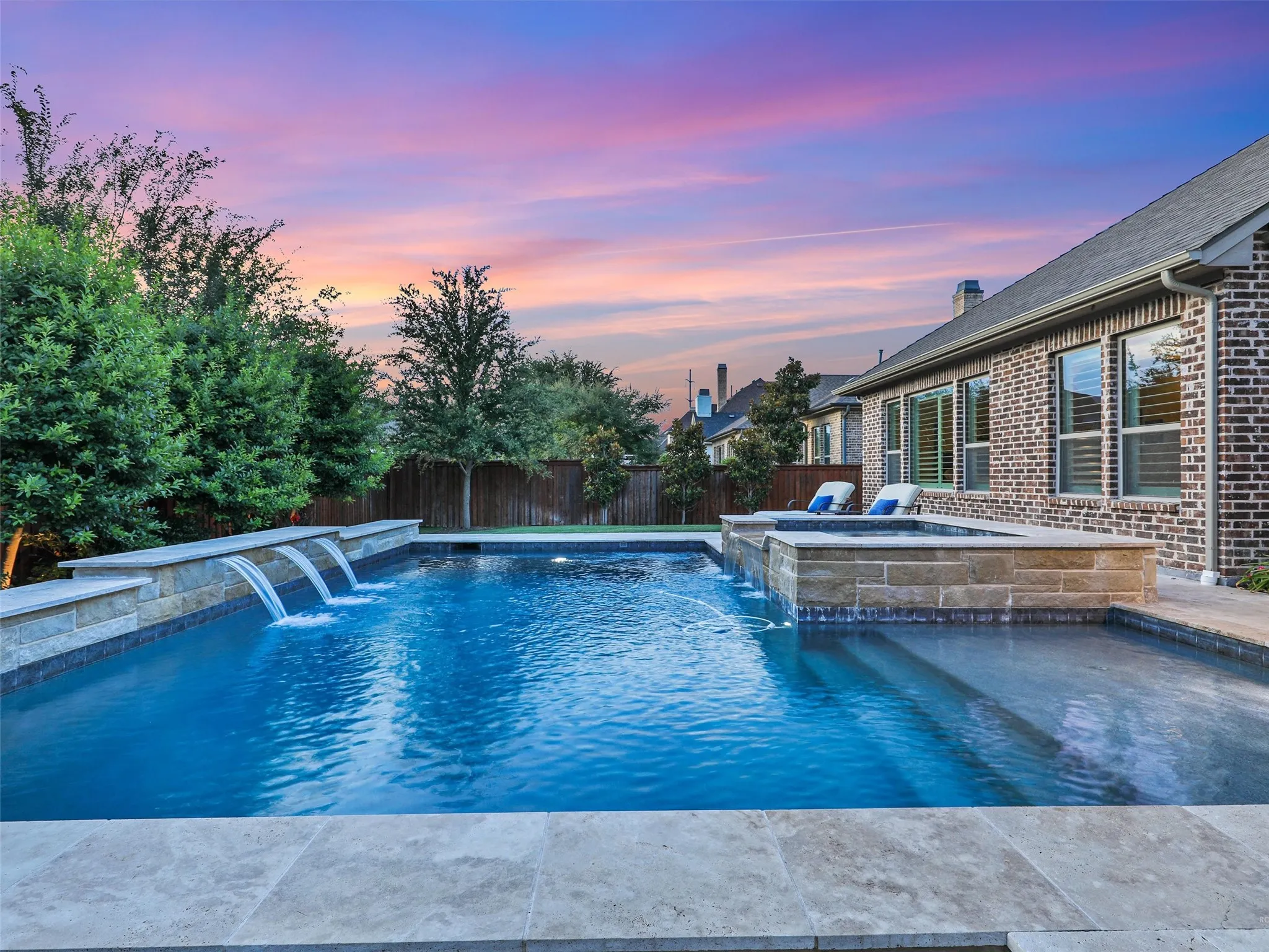 Outside, the property transforms into a private resort designed for year-round enjoyment. The Foley Pools swimming pool, completed in 2021, is complemented by an oversized spa with seating for approximately 10. Travertine limestone surrounds the pool and is used throughout the decking and coping, giving the outdoor environment a cohesive, upscale finish. Pentair pool equipment with wireless controls provides convenient operation, while individual pumps for the pool features allow greater flexibility and independent control.