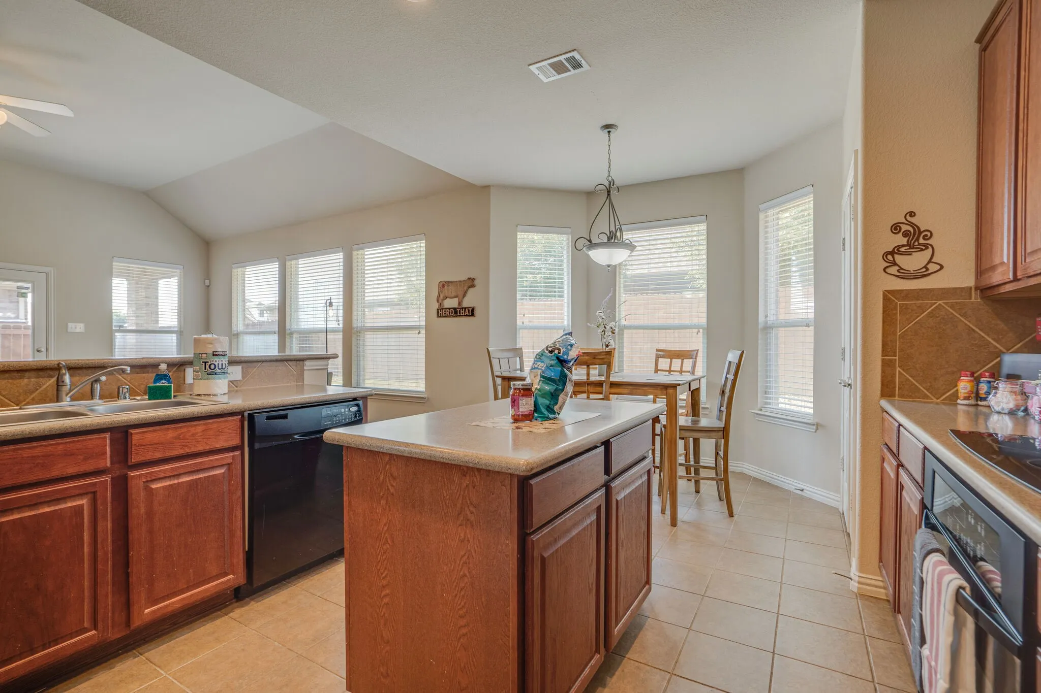 Kitchen featuring wood cabinetry, a center island, recessed lighting, and tile flooring