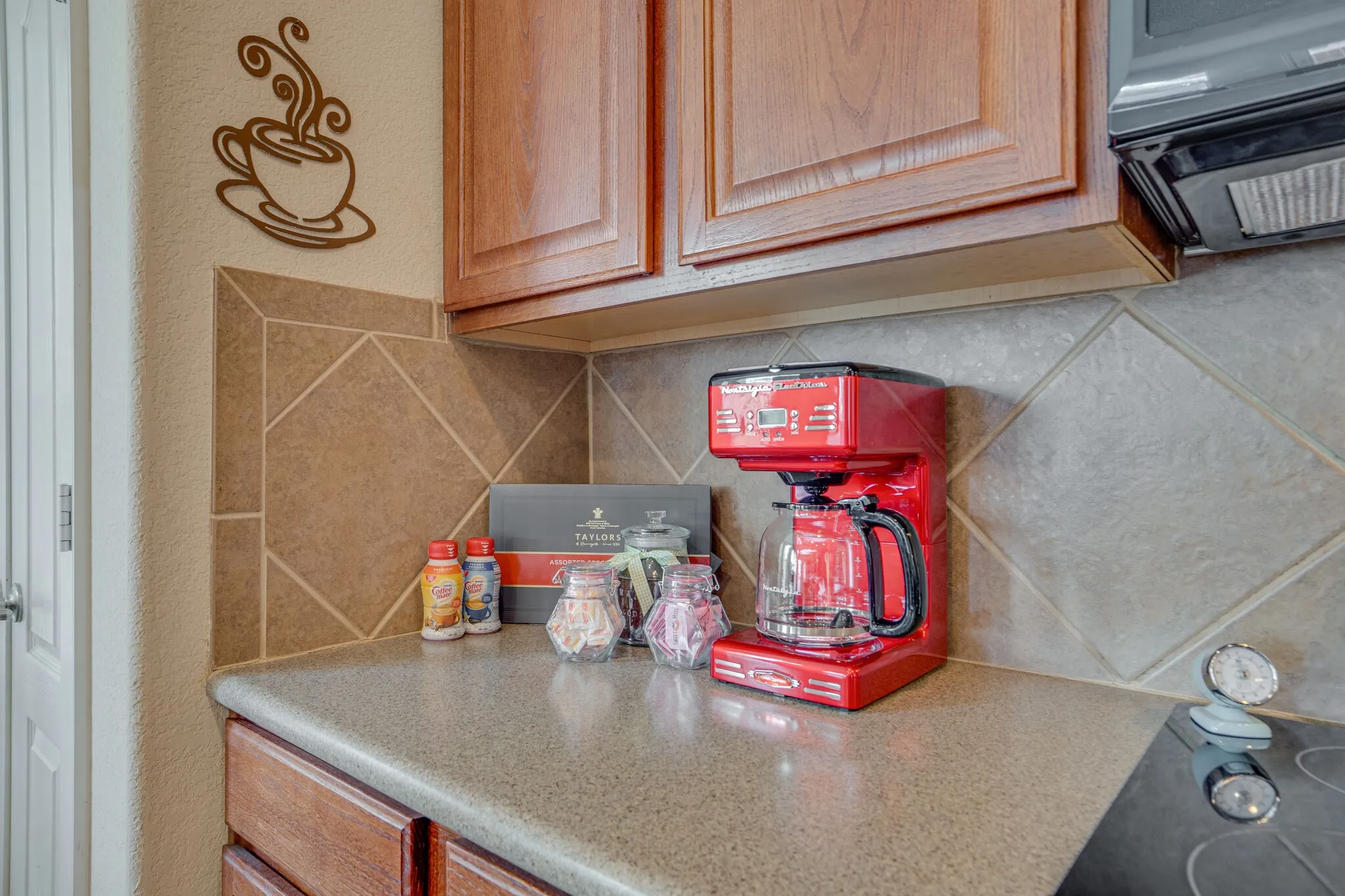 Wood-finish cabinetry paired with a tile backsplash and a solid surface countertop