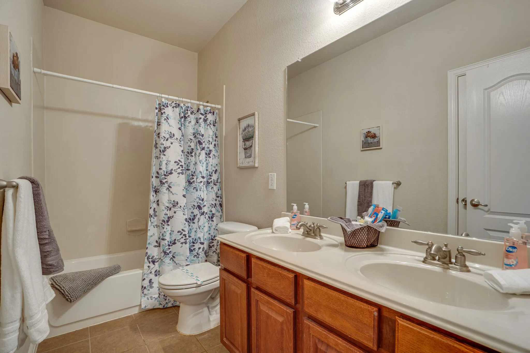Dual vanity with integrated sinks, wood-finish cabinetry, and brushed nickel fixtures