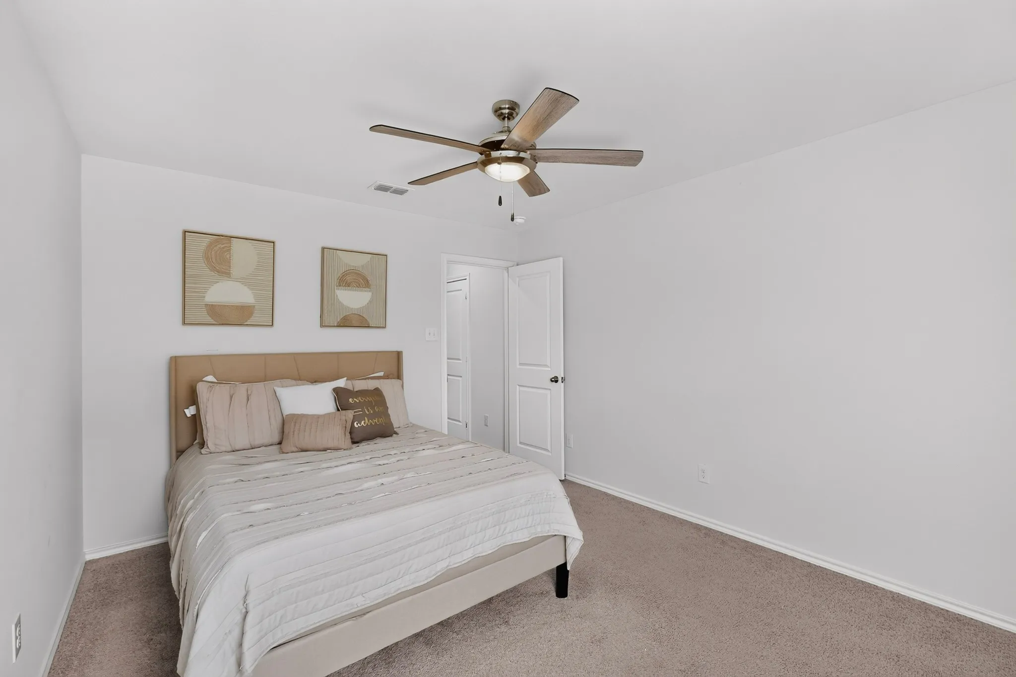Neutral wall tones, carpeted flooring, and a ceiling fan with integrated lighting