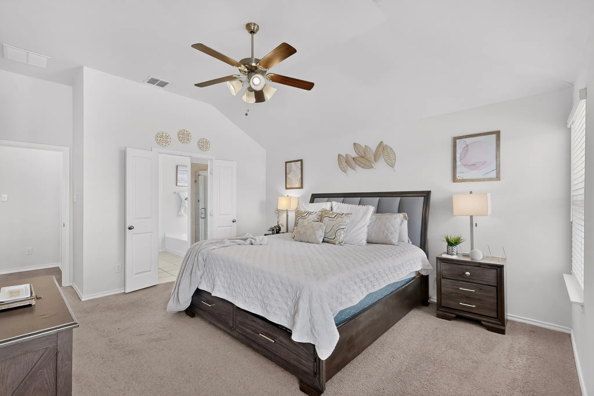 Vaulted ceiling with a ceiling fan, light gray carpeting, and white interior doors