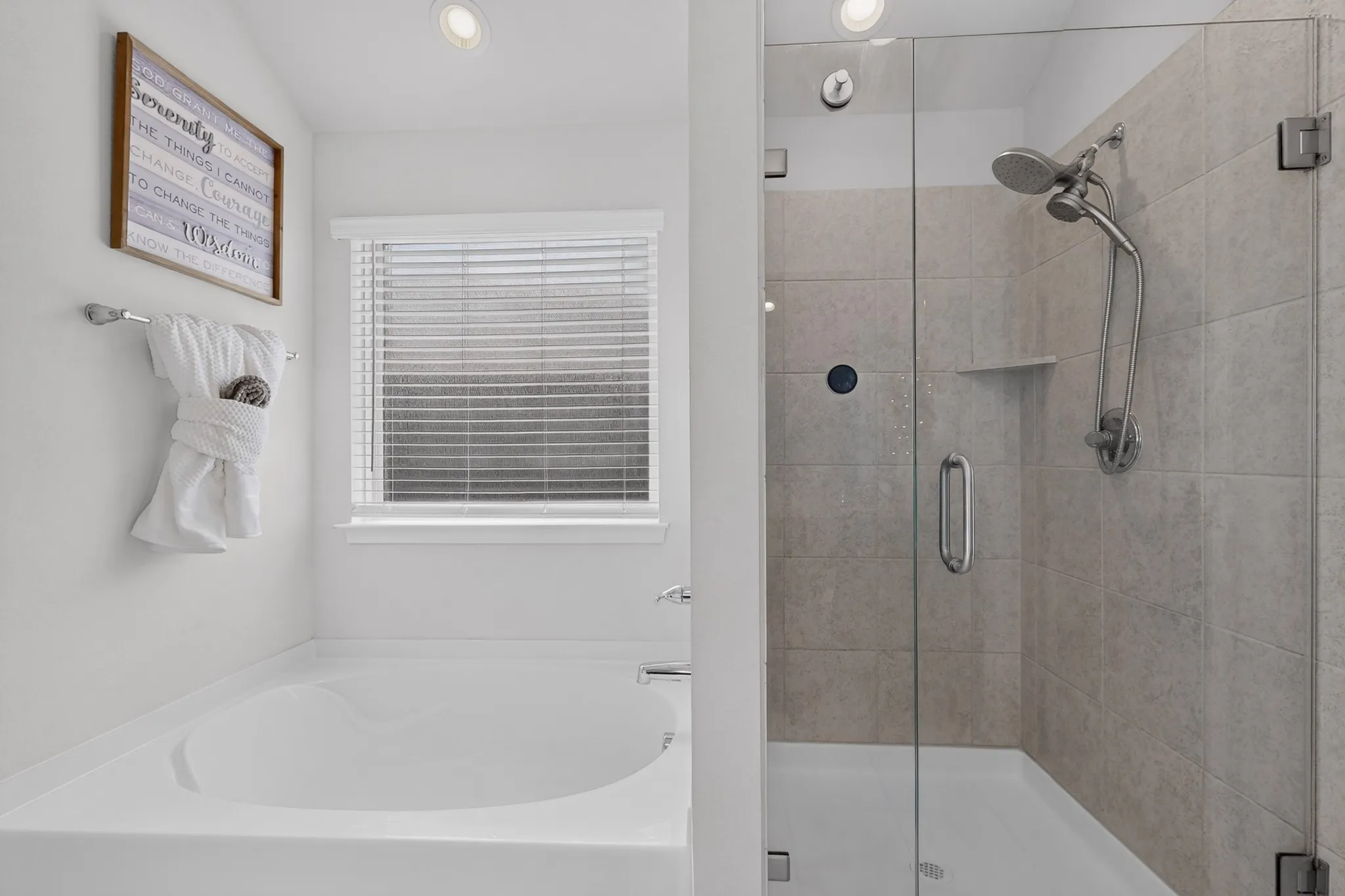 Built-in soaking tub, separate glass-enclosed shower with tile surround, recessed lighting, and a window with blinds