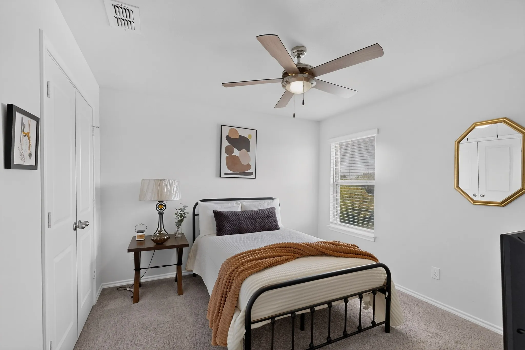 Built-in closet with double doors, overhead ceiling fan with lighting, window with blinds, and wall-to-wall carpeting