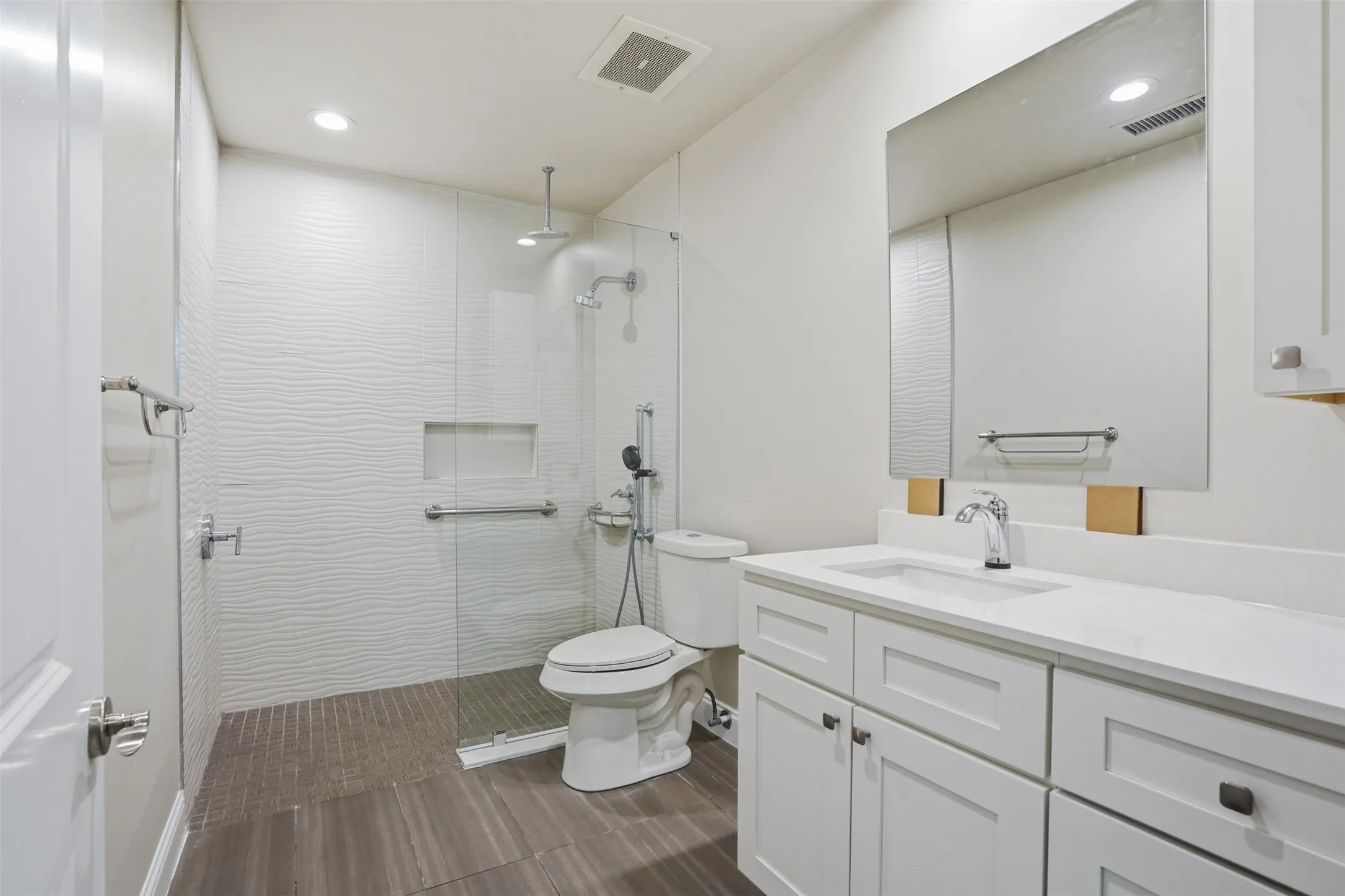Ensuite Second Bedroom Bath features Recessed lighting illuminating a glass-enclosed shower with a textured tile surround and a built-in niche