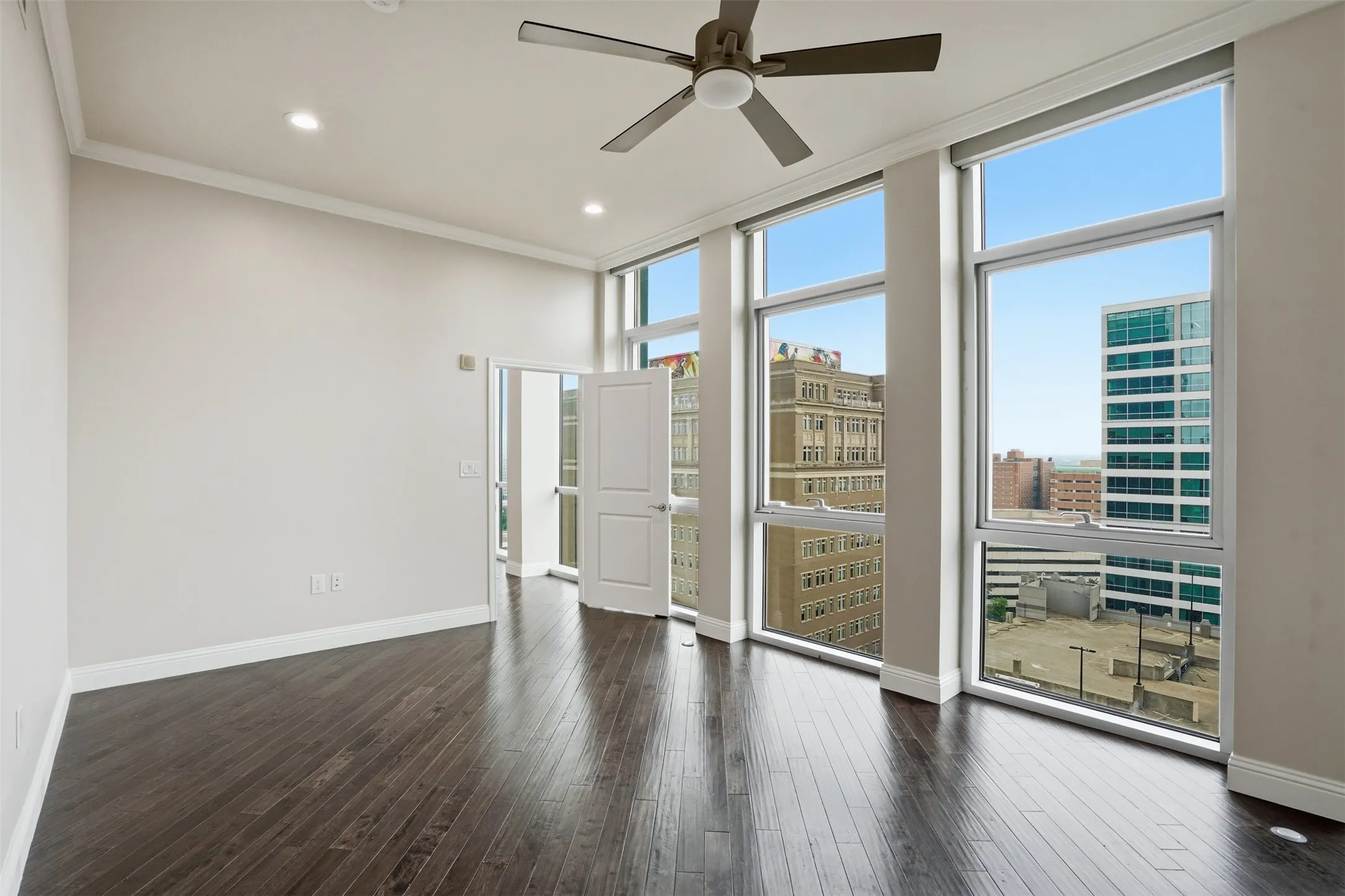 High ceilings, dark wood-finish flooring, recessed lighting, ceiling fan, and extensive windows