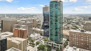 Expansive city landscape featuring diverse architectural structures and a prominent high-rise building with a glass facade