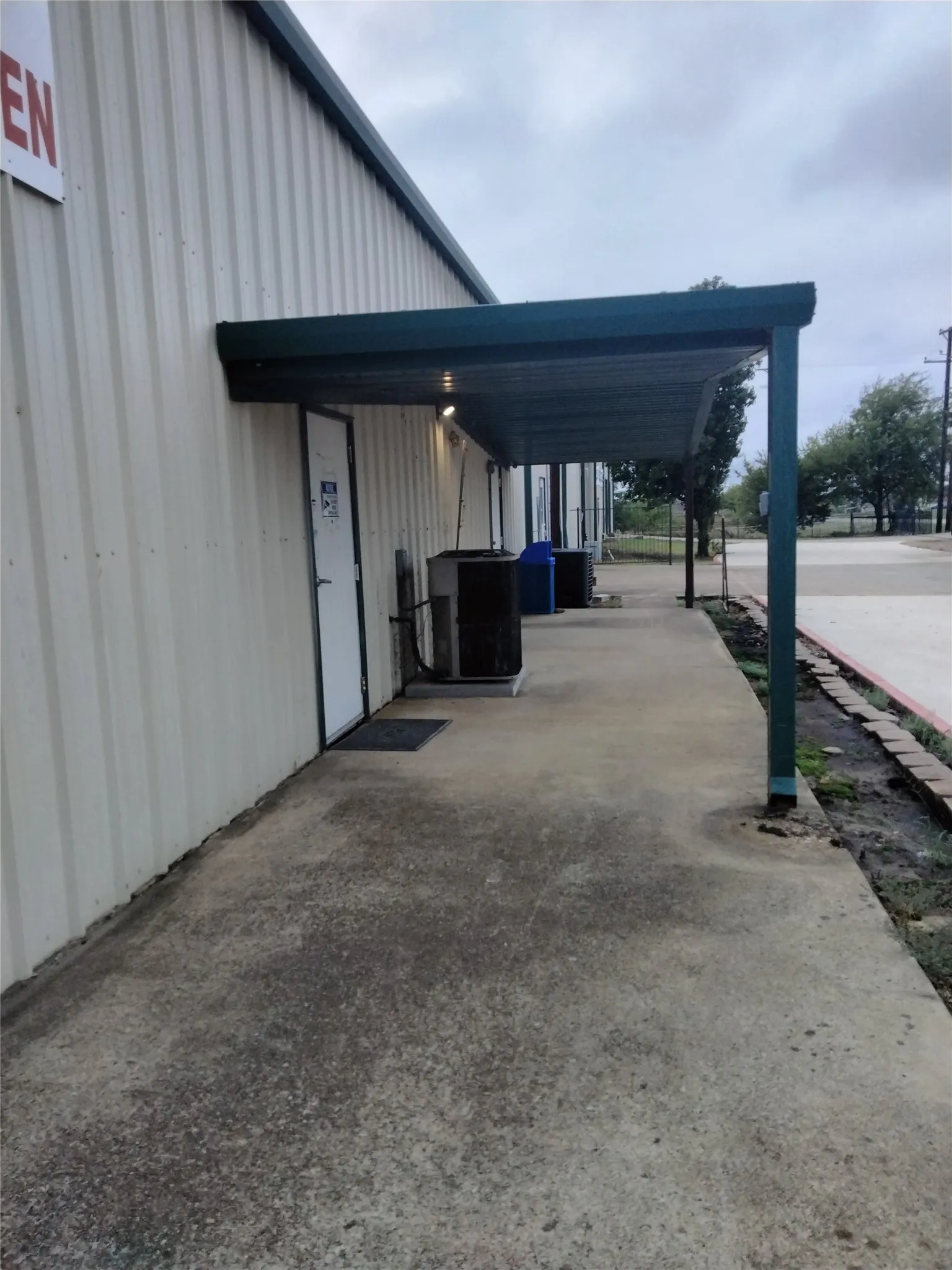 Corrugated metal siding with an extended awning