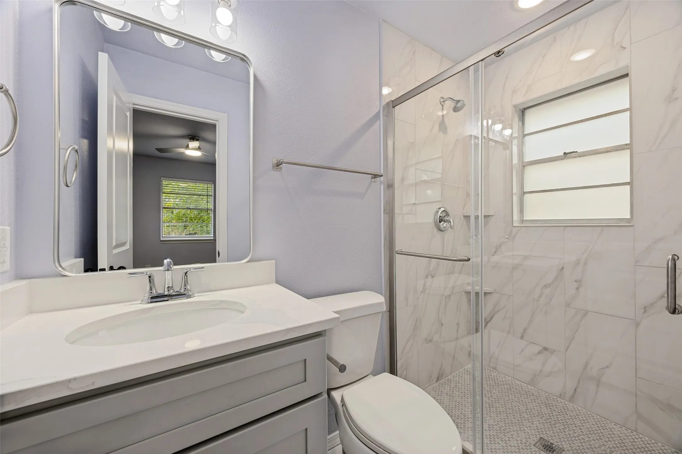 Full vanity with an integrated sink, polished chrome faucet, and rectangular mirror