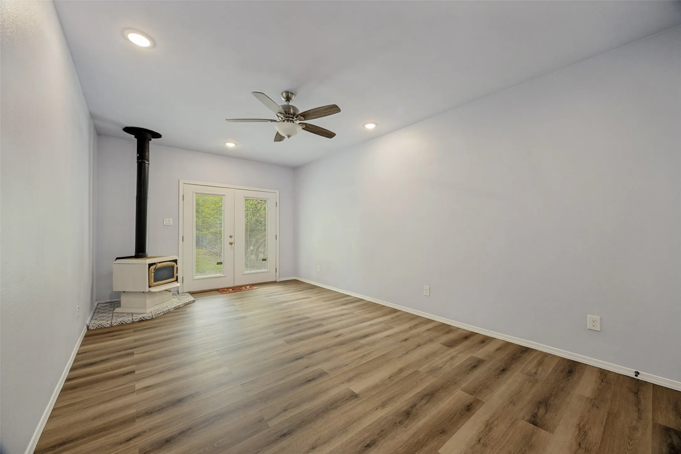 Wood-finish flooring, recessed lighting, and a ceiling fan
