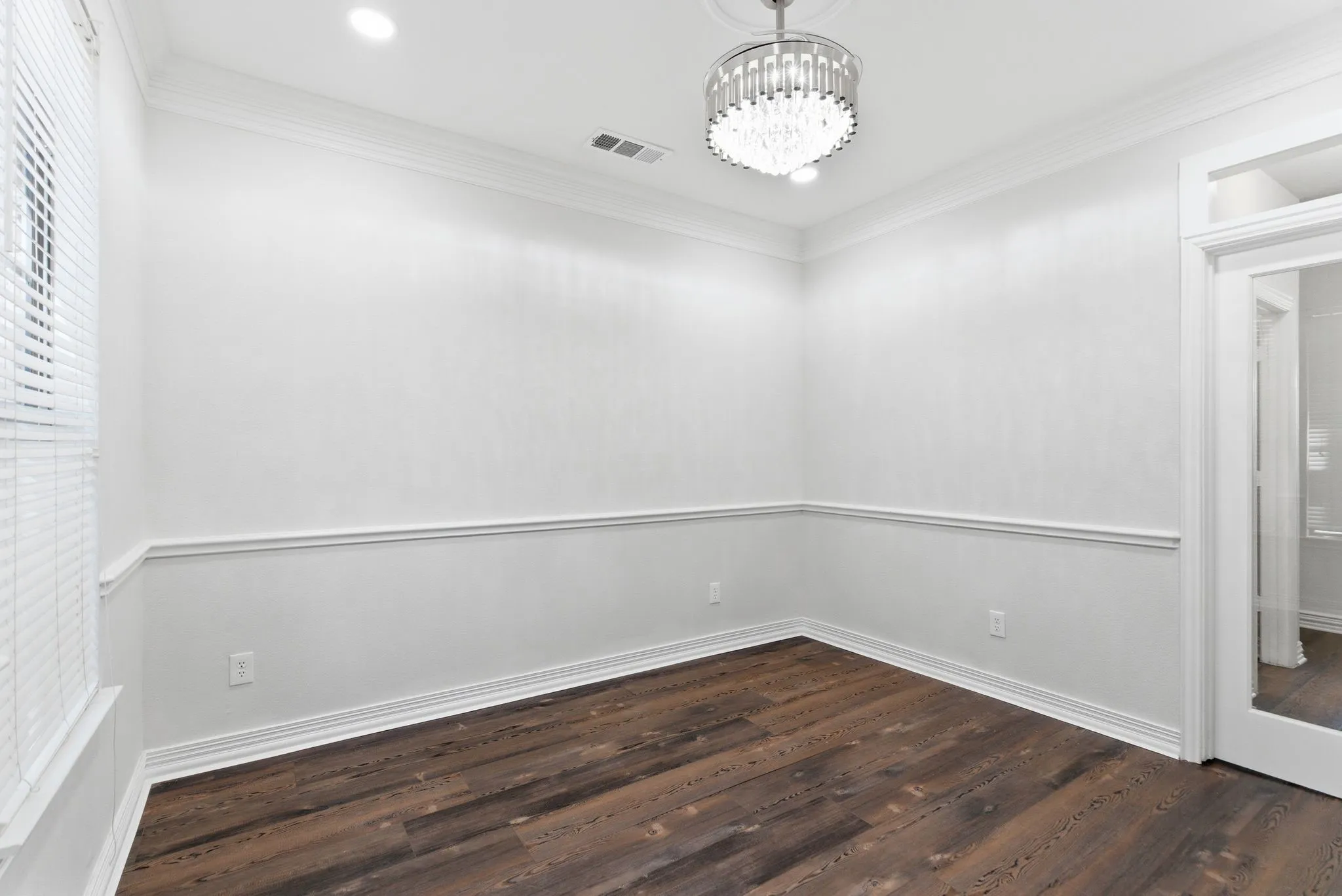 Crown molding with recessed lighting, detailed chandelier, wood-finish flooring, and chair rail molding