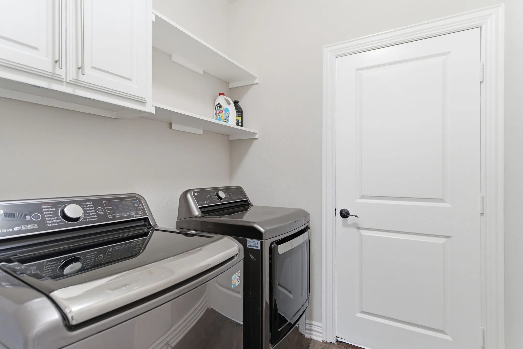 White cabinetry, open shelving, and wood-finish flooring