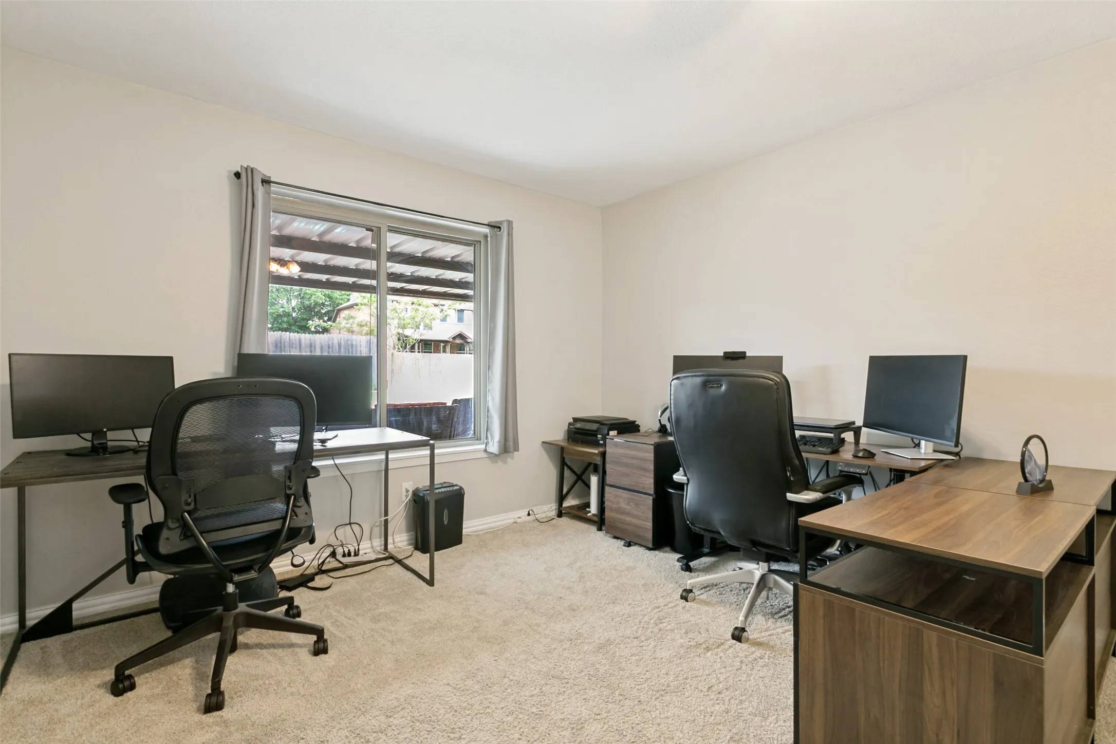 Recessed lighting, light-toned carpeting, and a window with curtains