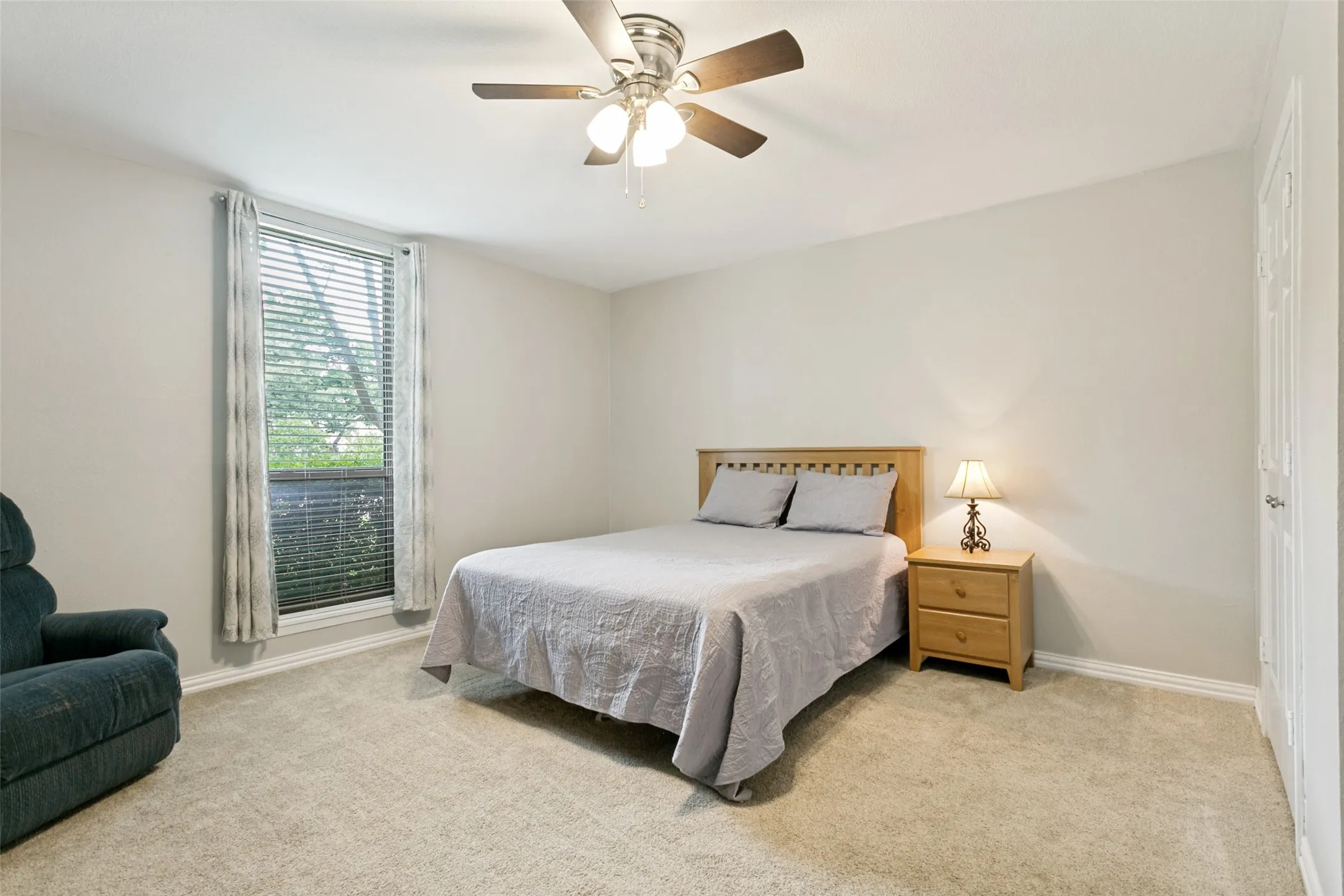 Ceiling fan with light fixture, carpeted flooring, window with blinds, and white trim