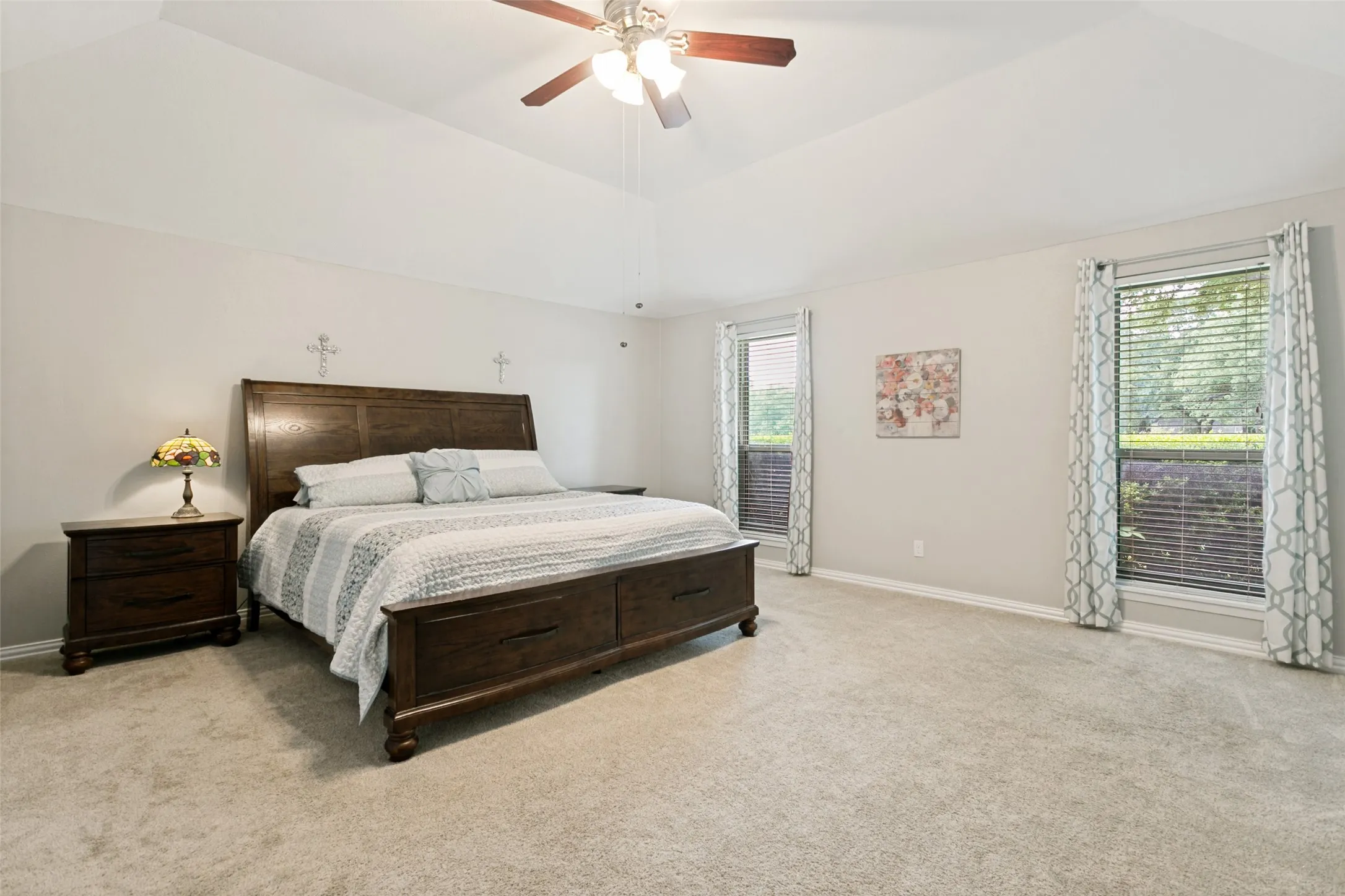 Tray ceiling, ceiling fan, carpeting, two windows, two large window blinds