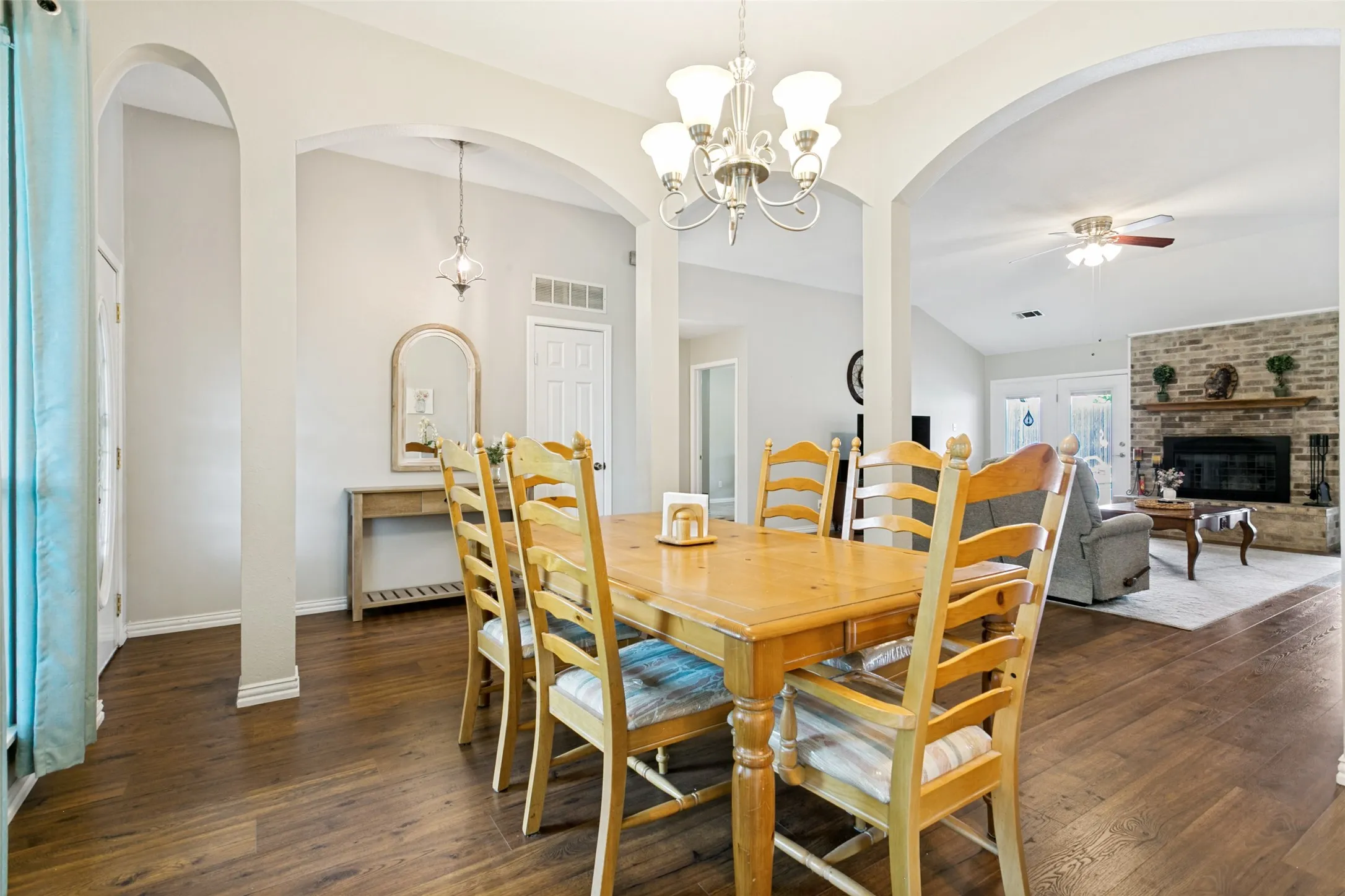 Wood-finish flooring throughout, with arched doorways and a chandelier fixture