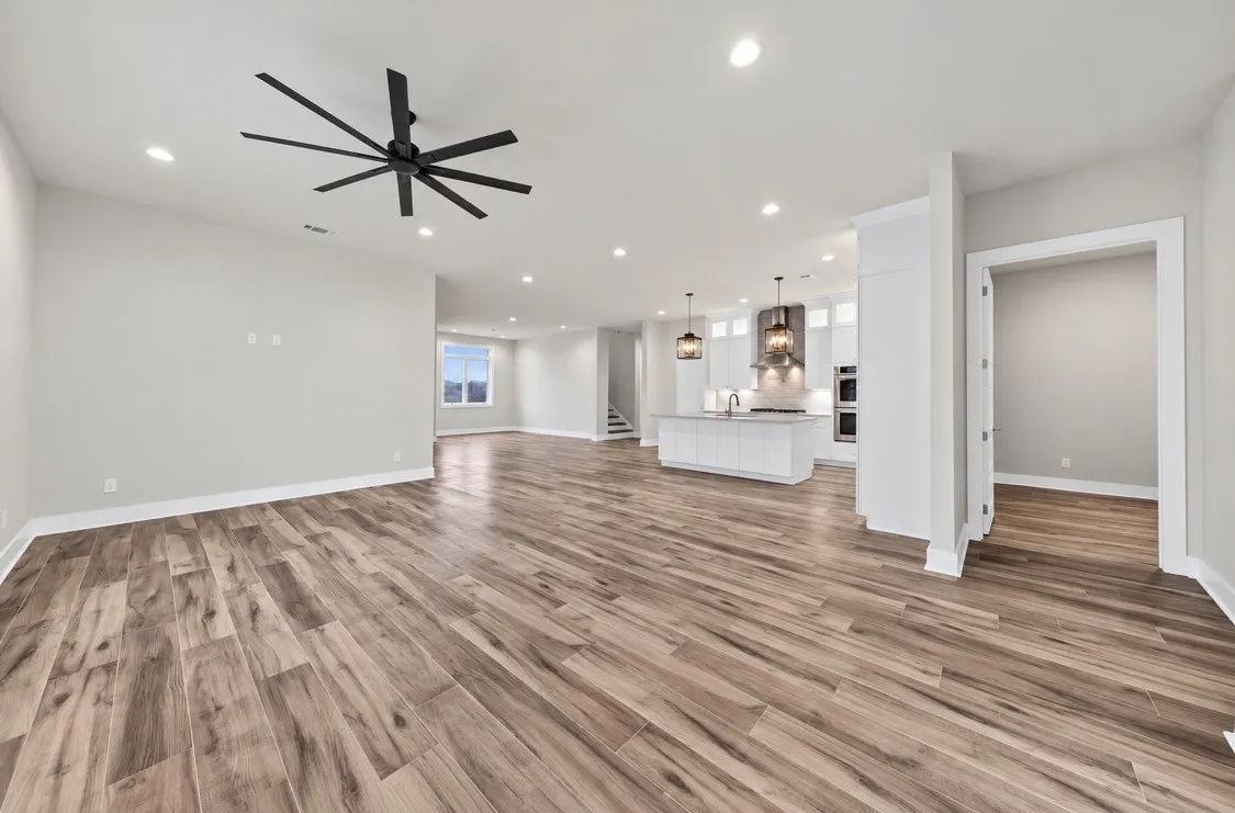 Open-concept living area featuring wood-finish flooring, recessed lighting, and a contemporary ceiling fan