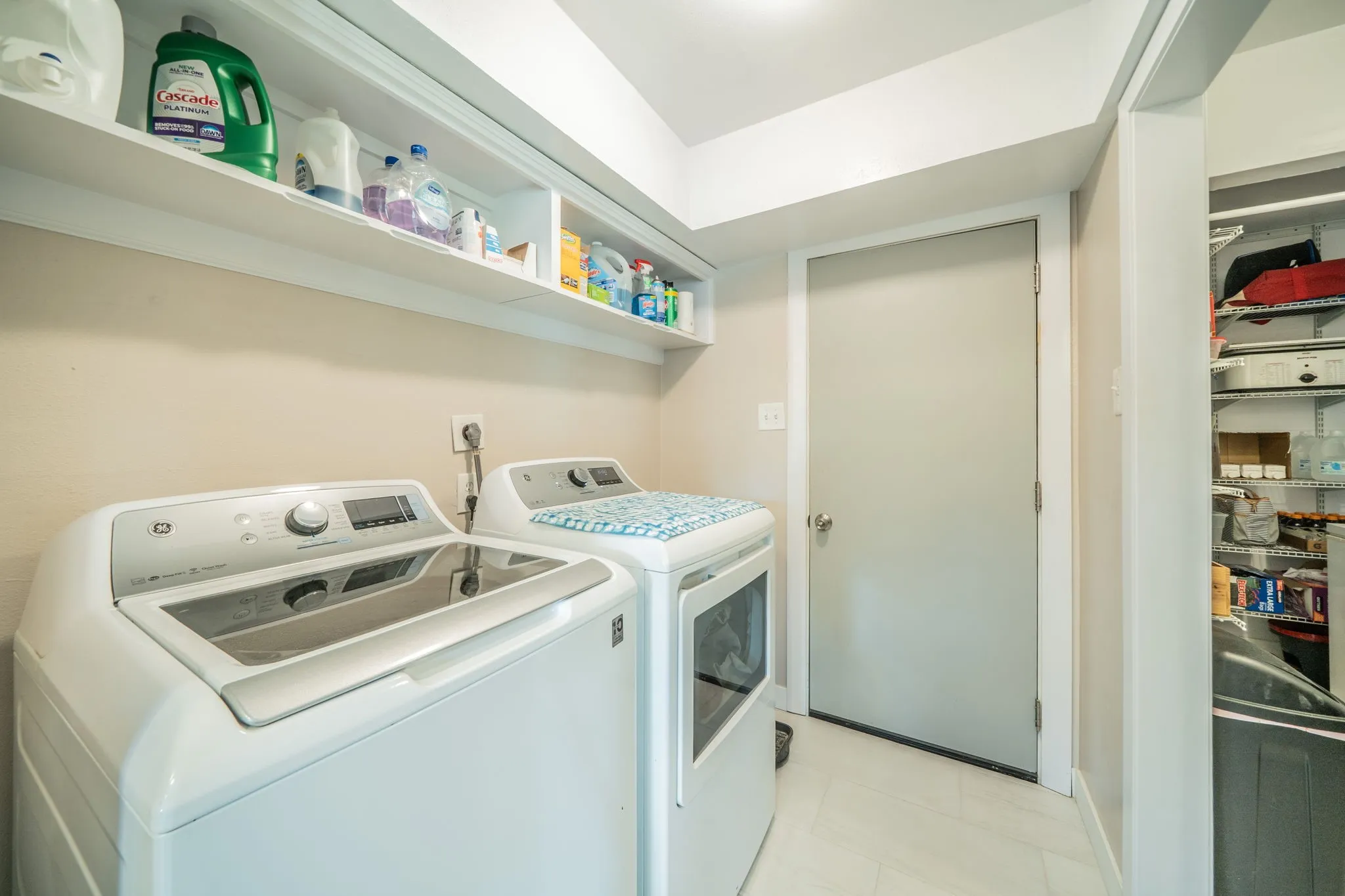Built-in wall shelving, light-toned wall paint, recessed lighting, and tile flooring