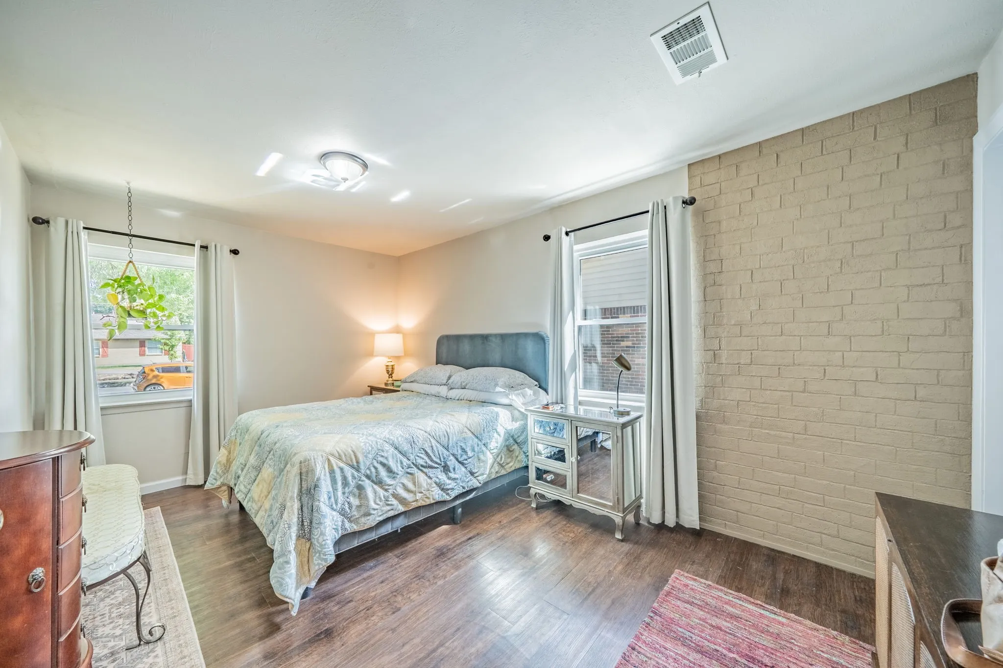  accent brick wall, recessed lighting, and multiple windows with curtain rods