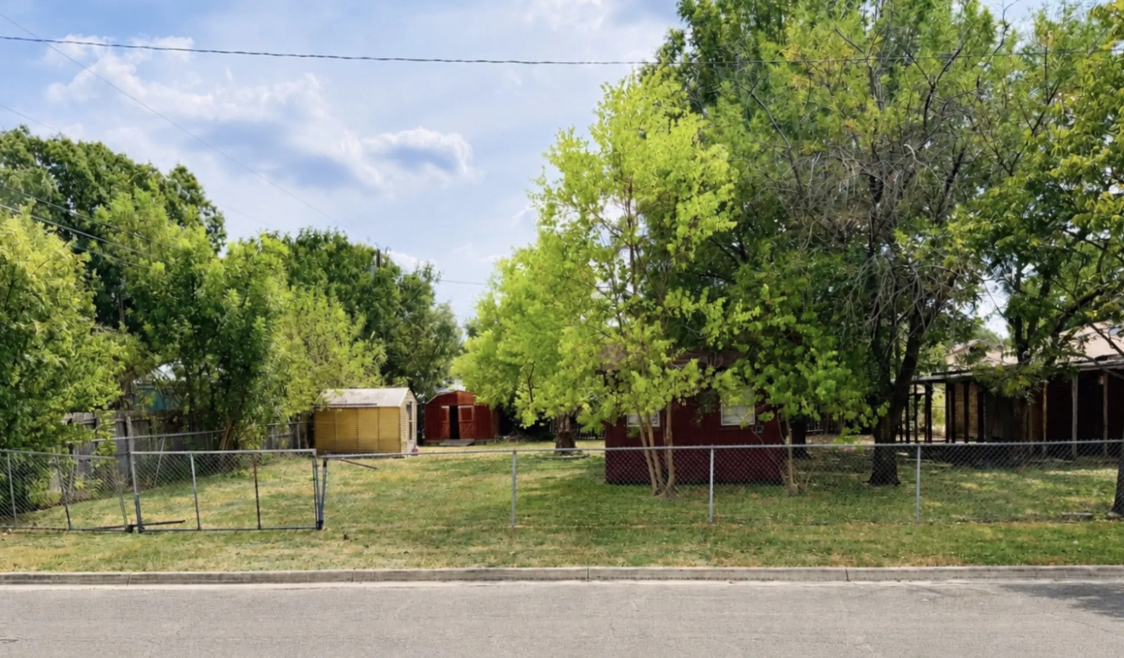 The expansive backyard, framed by mature trees and crepe myrtles, offers a peaceful setting for outdoor living, with exciting possibilities such as a casita, space for an RV, a pool or garden.