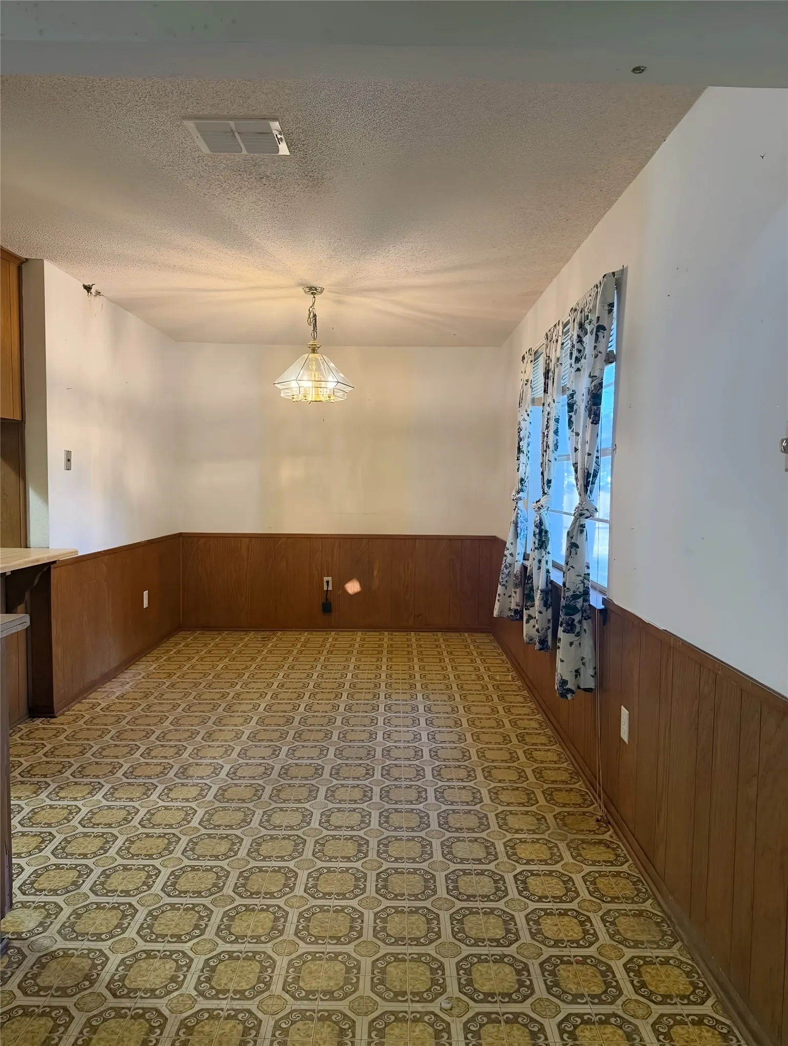 This roomy dining room has ample floor space to accommodate a dining table and chairs and a full size china cabinet or buffet.